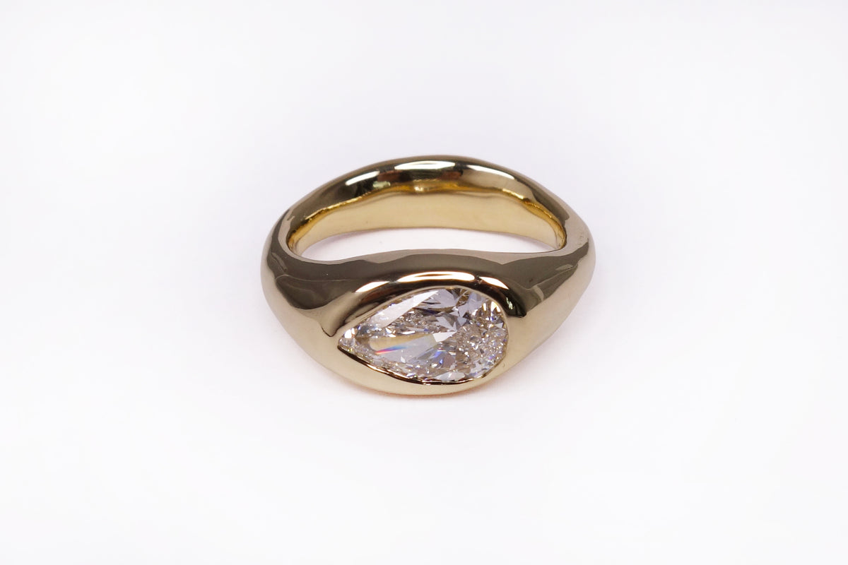 talisman fine jewelry jill solitaire ring with a natural pear cut diamond flush set in a chunky 14k gold domed band