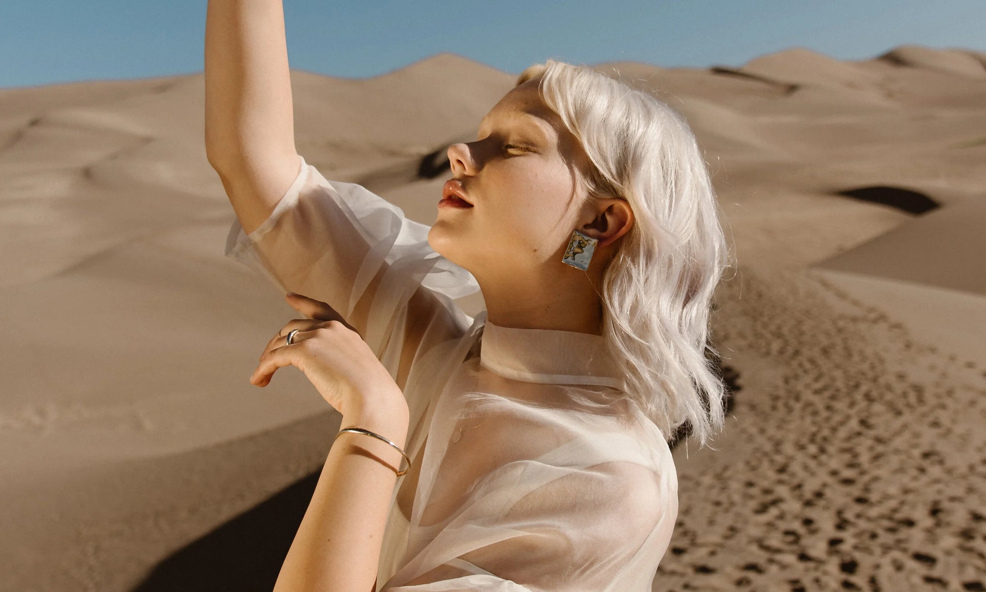 Model Aleah Hyvonen wears the Plane Earrings, Portal Bracelet, Goldyn Hammered Stacking Ring, and Rollo Band. All sustainably handmade in recycled 14k gold using traditional lost-wax casting techniques.