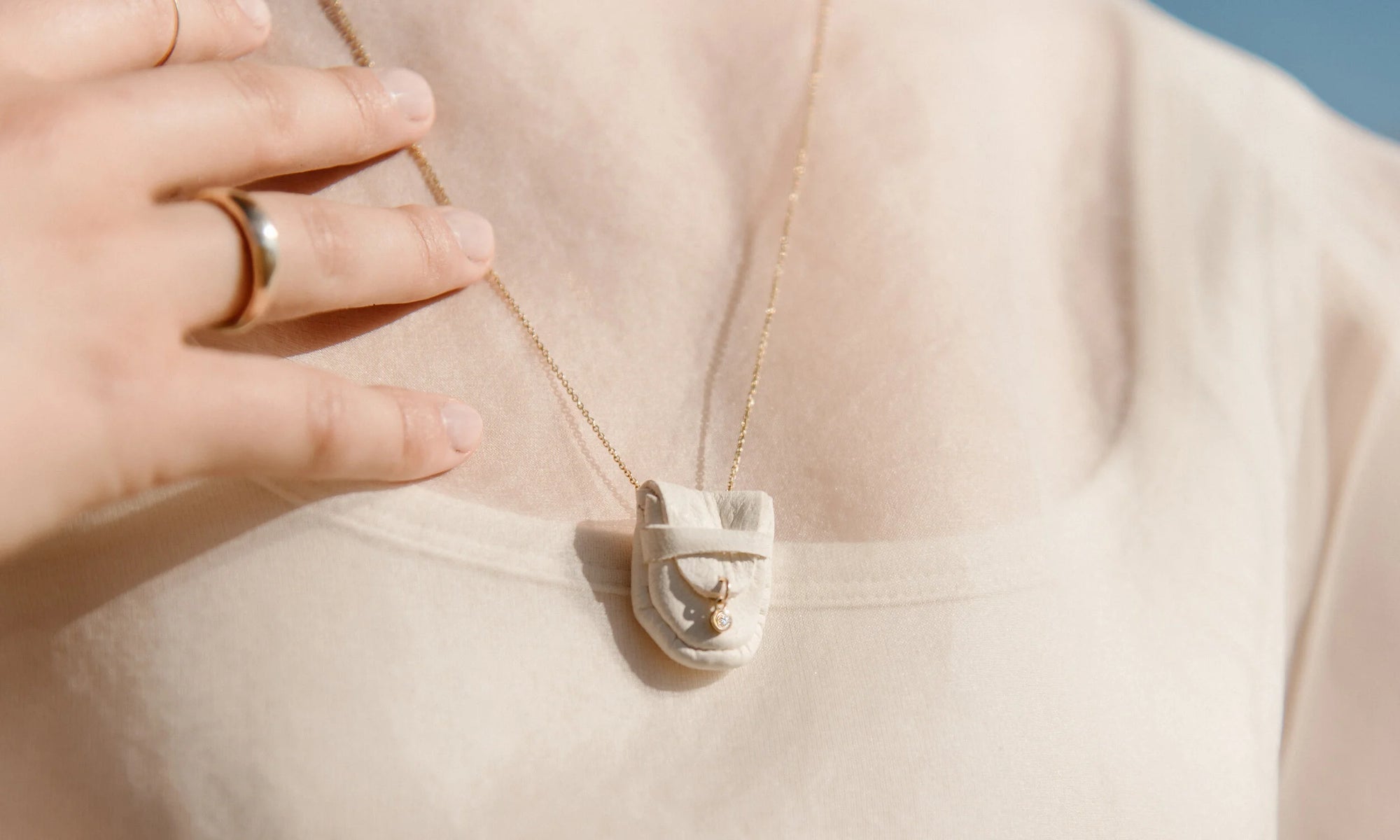 Model Aleah Hyvonen wears the Brilliant Diamond Talisman Pouch Necklace, Portal Ring, and Circle Shape Ring. All sustainably handmade in recycled 14k gold, using traditional lost-wax casting techniques.