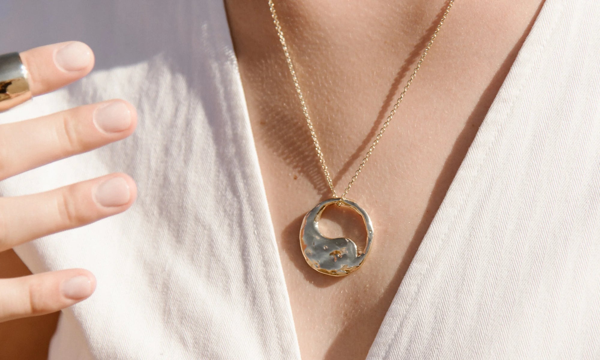 Model Aleah Hyvonen wears the Demeter Cigar Band and Yin Yang Necklace. Both sustainably handmade in recycled 14k gold, using traditional lost-wax casting techniques.