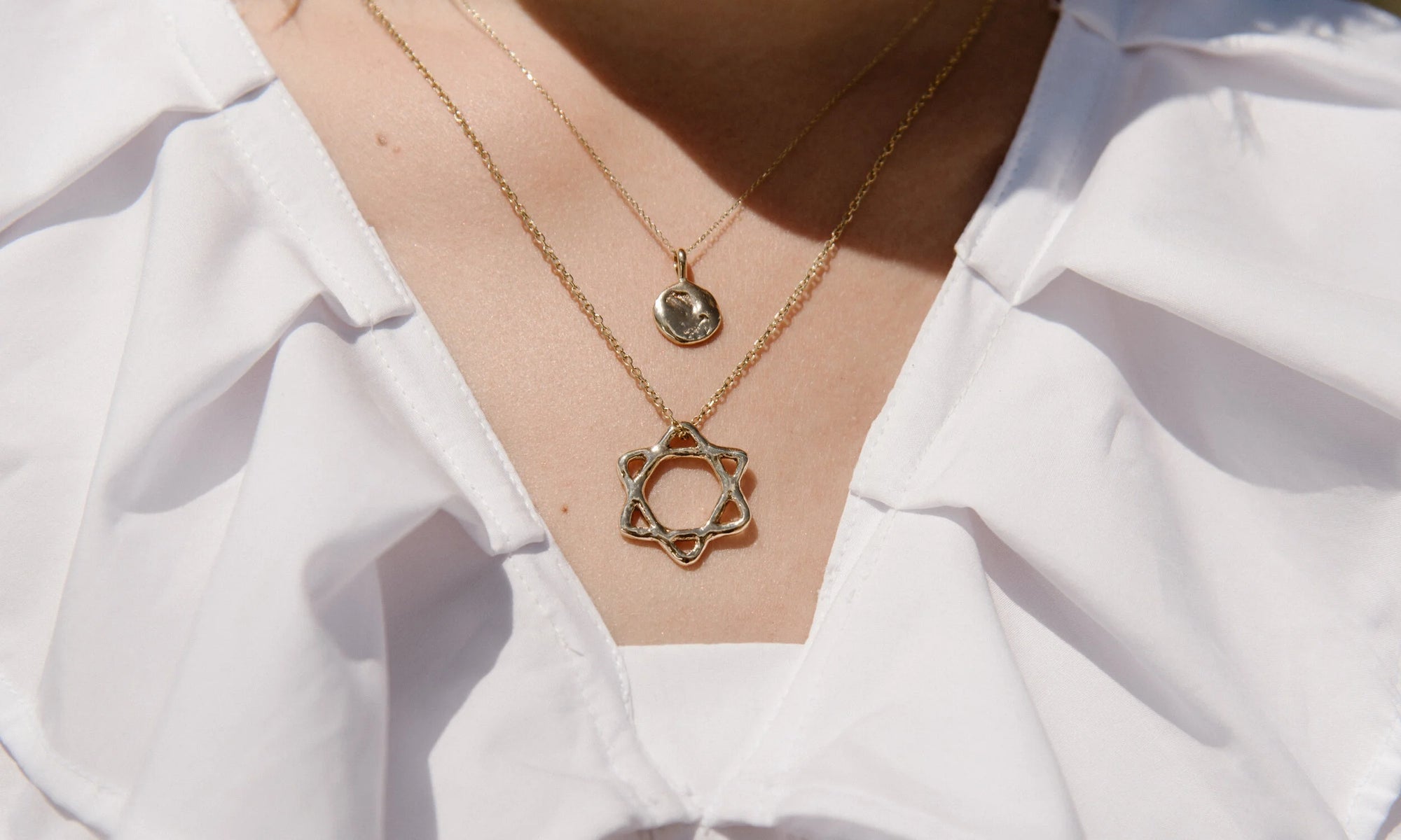 Model Aleah Hyvonen wears the Michael Amulet Necklace and Solomon's Seal Necklace. All sustainably handmade in recycled 14k gold, using traditional lost-wax casting techniques.
