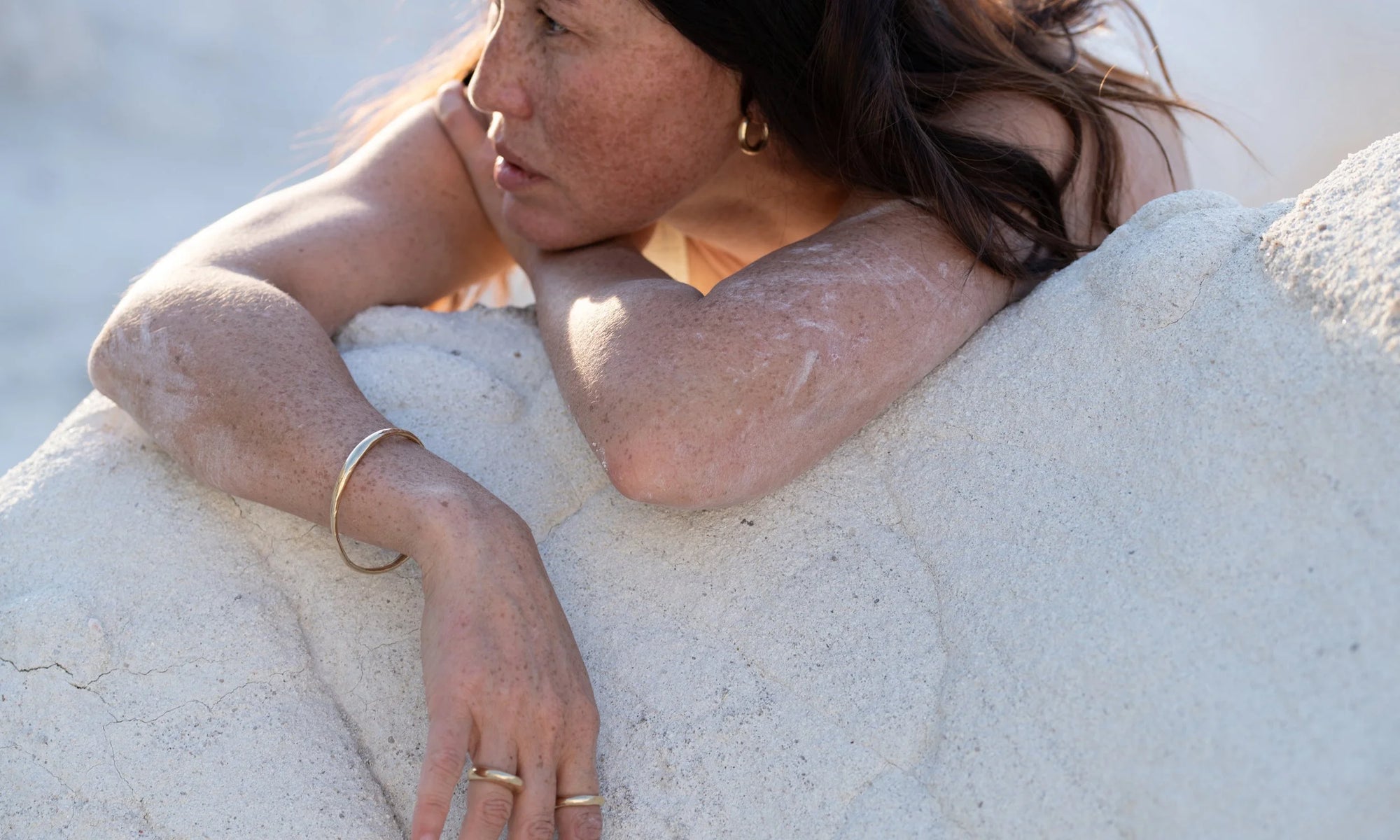 At rest. From top: The Rollo Hoops, Portal Bracelet, Persephone Ring, and Rollo Band. All sustainably handmade in recycled 14k gold.