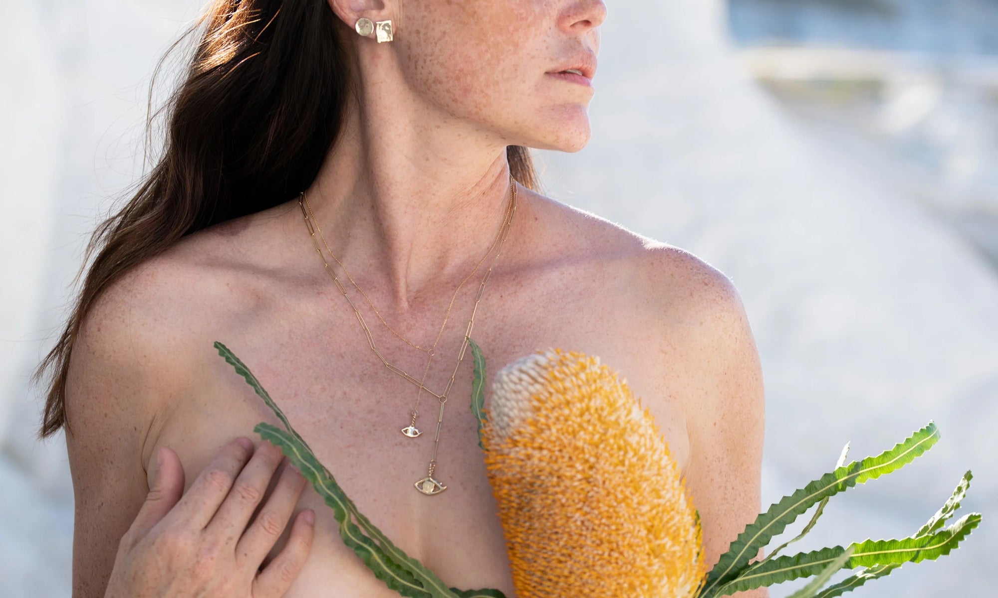 Sunshine wears the New Orb Studs, Petite Plane Studs, and both the Protective Eye Y Necklace and Mini Protective Eye Y Necklace. All sustainably handmade in recycled 14k gold.