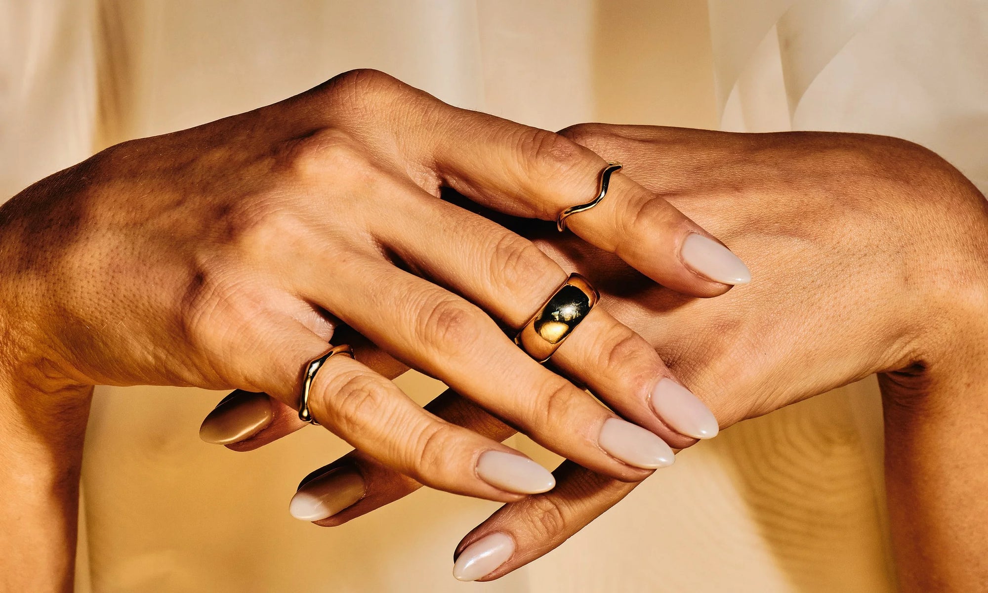 Vanessa Luka wears from left: Sirius C Ring, Conjunct Cigar Band and Wave Theory Ring. All entirely handmade using solid, recycled 14k gold.
