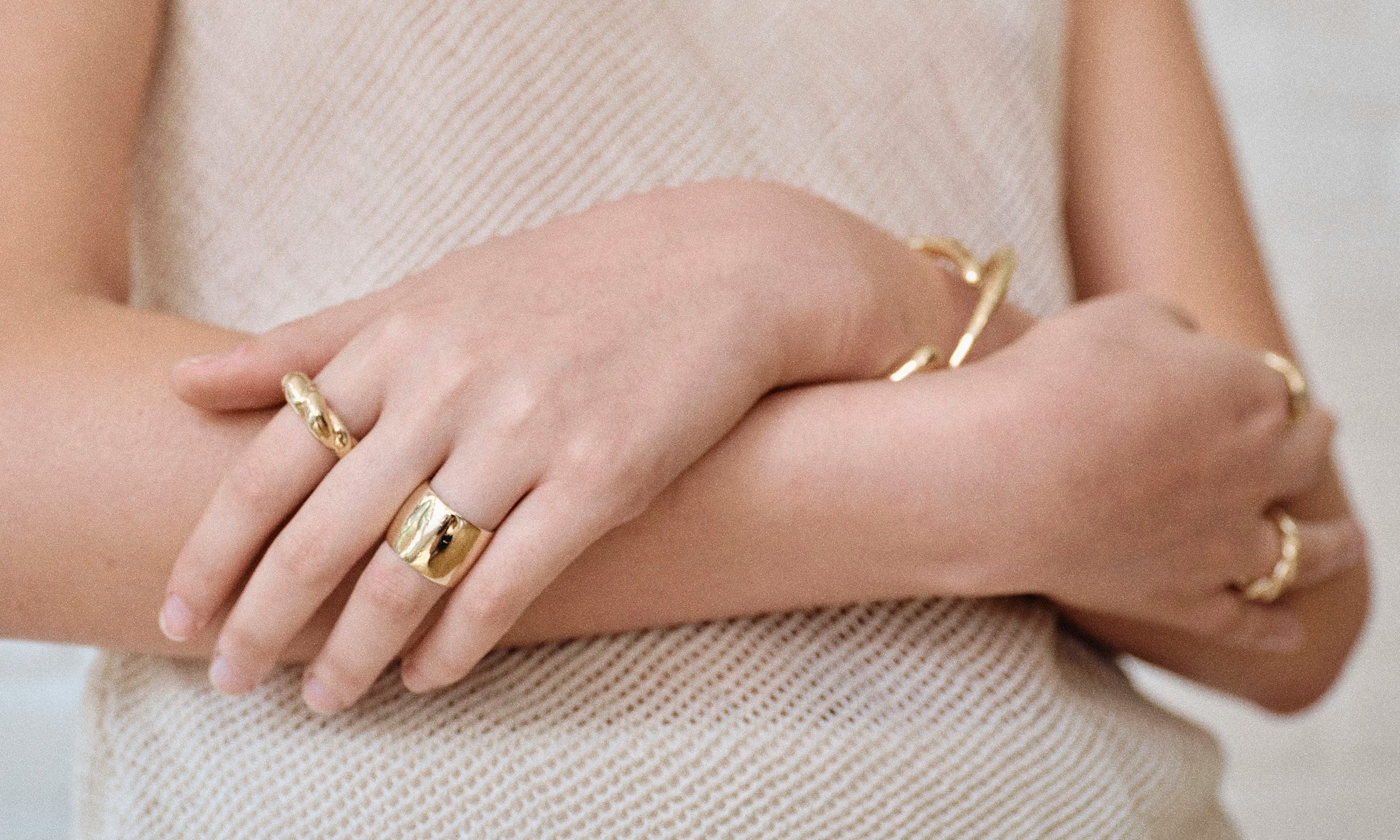 Model Rachel wears the Demeter Cigar Band, Helix Dome Ring, Portal Bracelet and Inverse Cuff. All sustainably handmade in solid recycled 14k gold by Talisman Fine Jewelry.