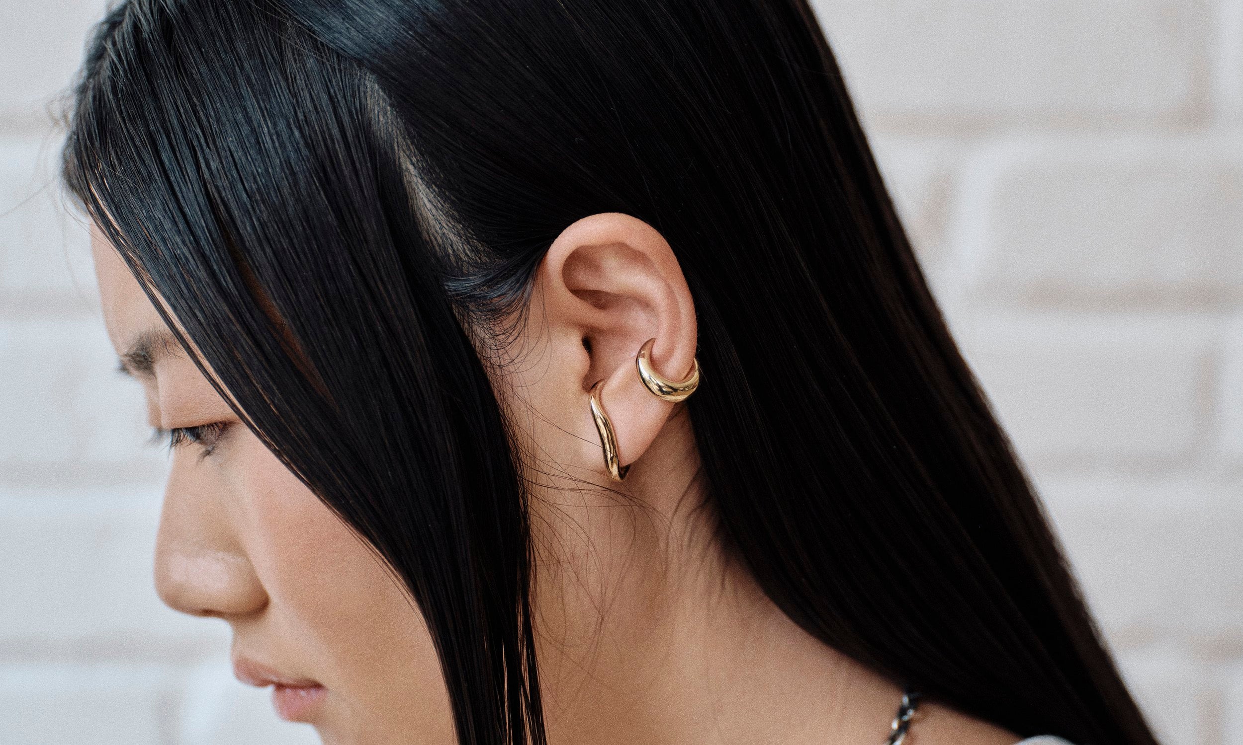 Model Rachel wears the Embrace Earring and Delphi Ear Cuff. Each piece of 14k gold jewelry is hand sculpted by Talisman Fine Jewelry.