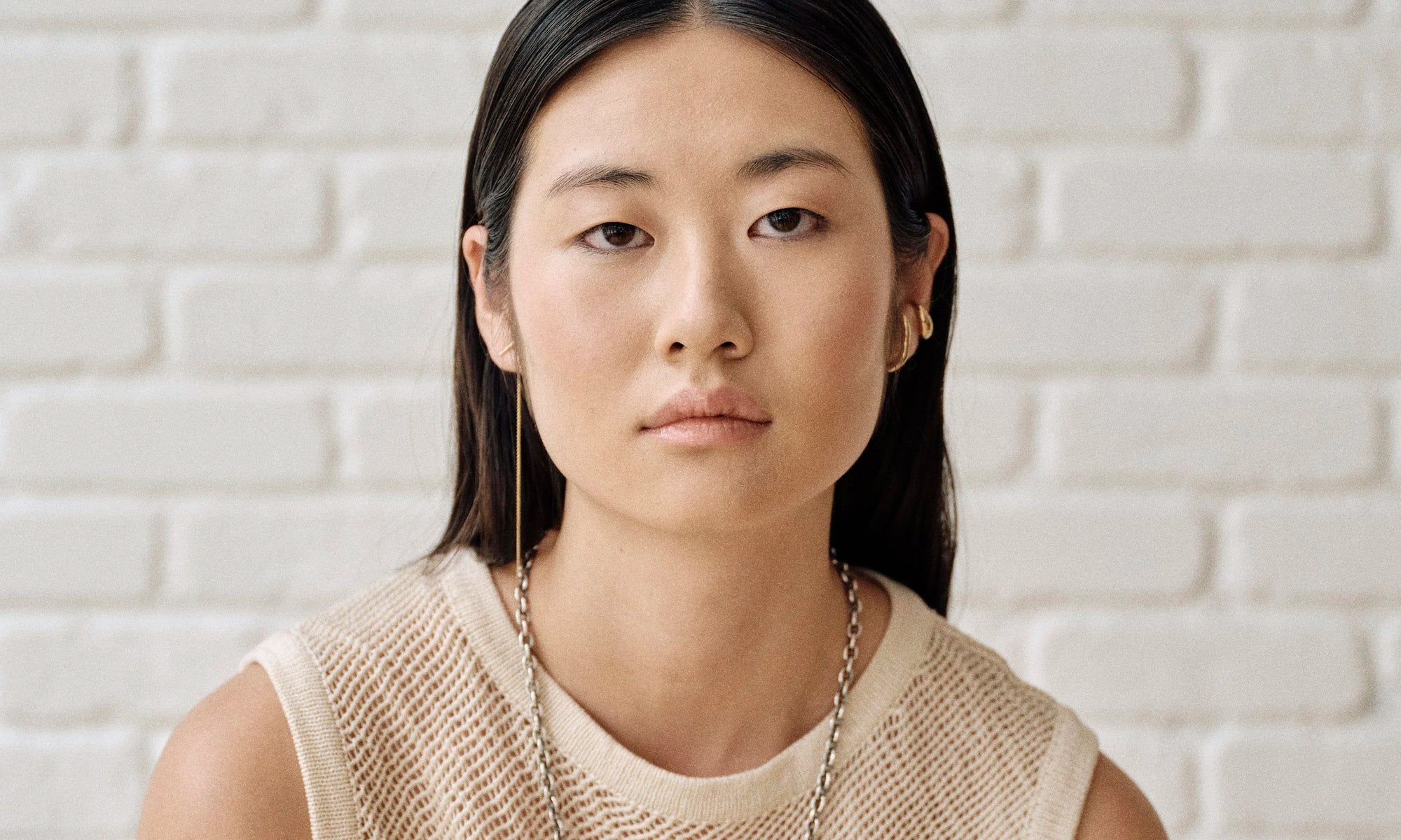 Model Rachel wears the Linear Threader Earring, Embrace Earring, and Delphi Ear Cuff. Ethically sourced and handmade from solid 14k recycled gold.
