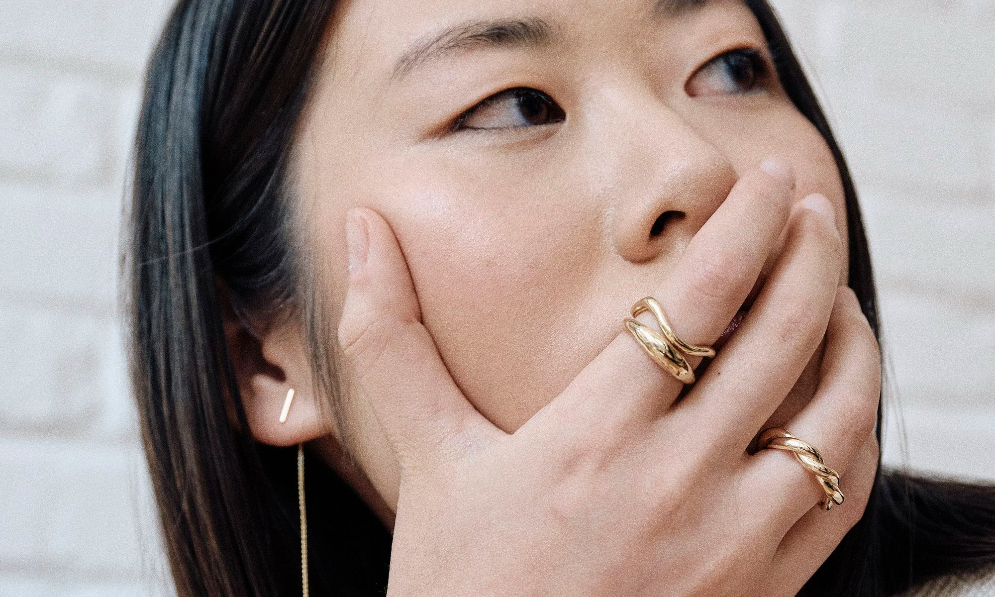 Model Rachel wears the Linear Threader Earring, Portal Ring, Shapeshifter Ring, and Helix Band. All sustainably handmade in solid recycled 14k gold by Talisman Fine Jewelry.