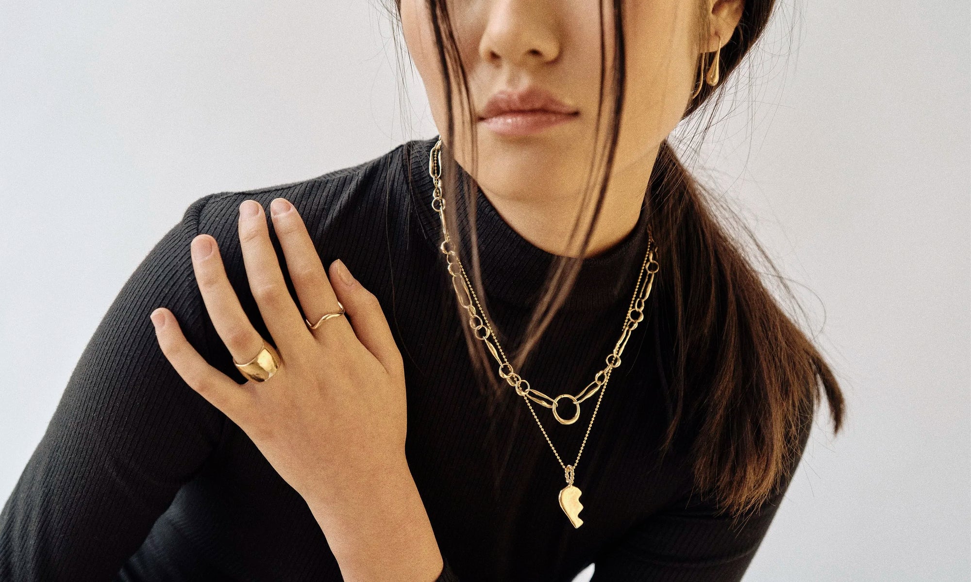 Model Rachel wears the Demeter Cigar Band, Wave Theory Ring, Metanoia Necklace, Left BFF Necklace, and Sanguine Drop Earring. All sustainably handmade in solid recycled 14k gold by Talisman Fine Jewelry.