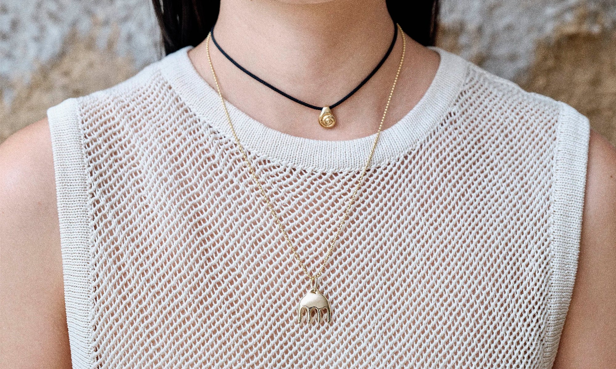 Model Rachel wears the Ariel's Comb Necklace and the Growth Necklace on silk cord. Each piece is handmade from recycled 14k gold.