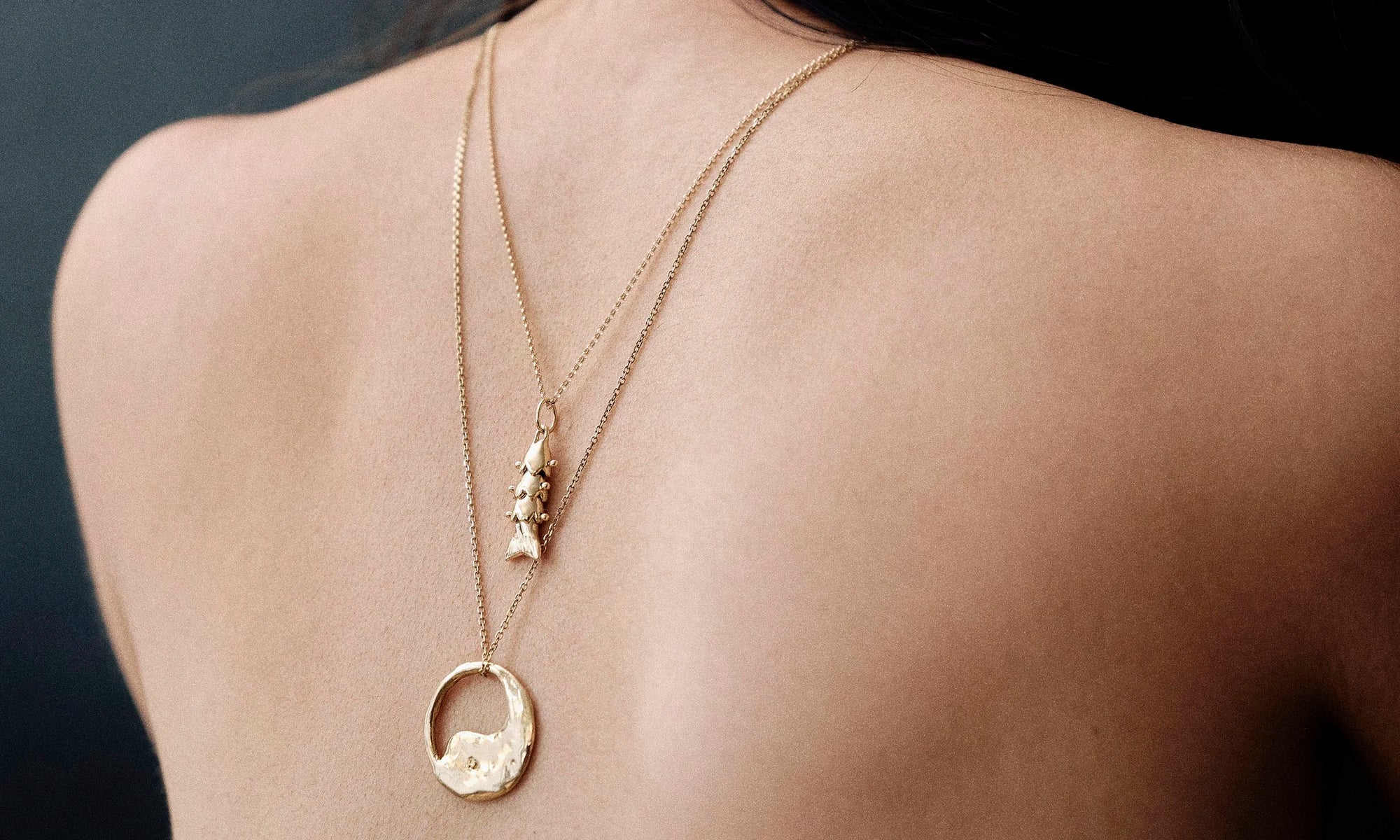 Model Rachel wears the Piscean Dream Necklace and Yin Yang Necklace. Each piece is hand sculpted and sustainably made of recycled 14k gold.