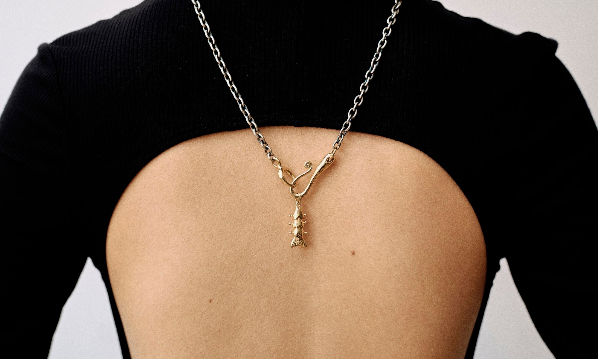 Model Rachel wears the two-tone Duality Necklace with the Piscean Dream pendant. All sustainably handmade in recycled 14k gold by Talisman Fine Jewelry.