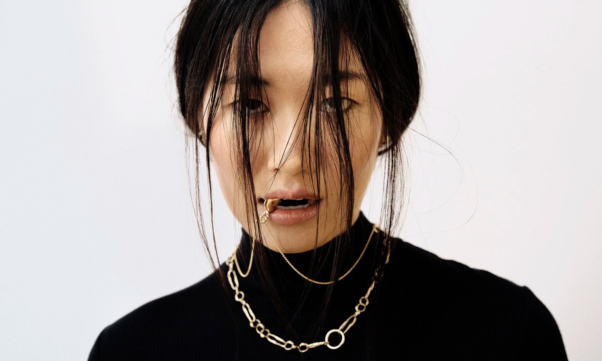 Model Rachel wears the Held Earrings, Metanoia Chain, and the Left BFF Necklace. All sustainably handmade in recycled 14k gold by Talisman Fine Jewelry.