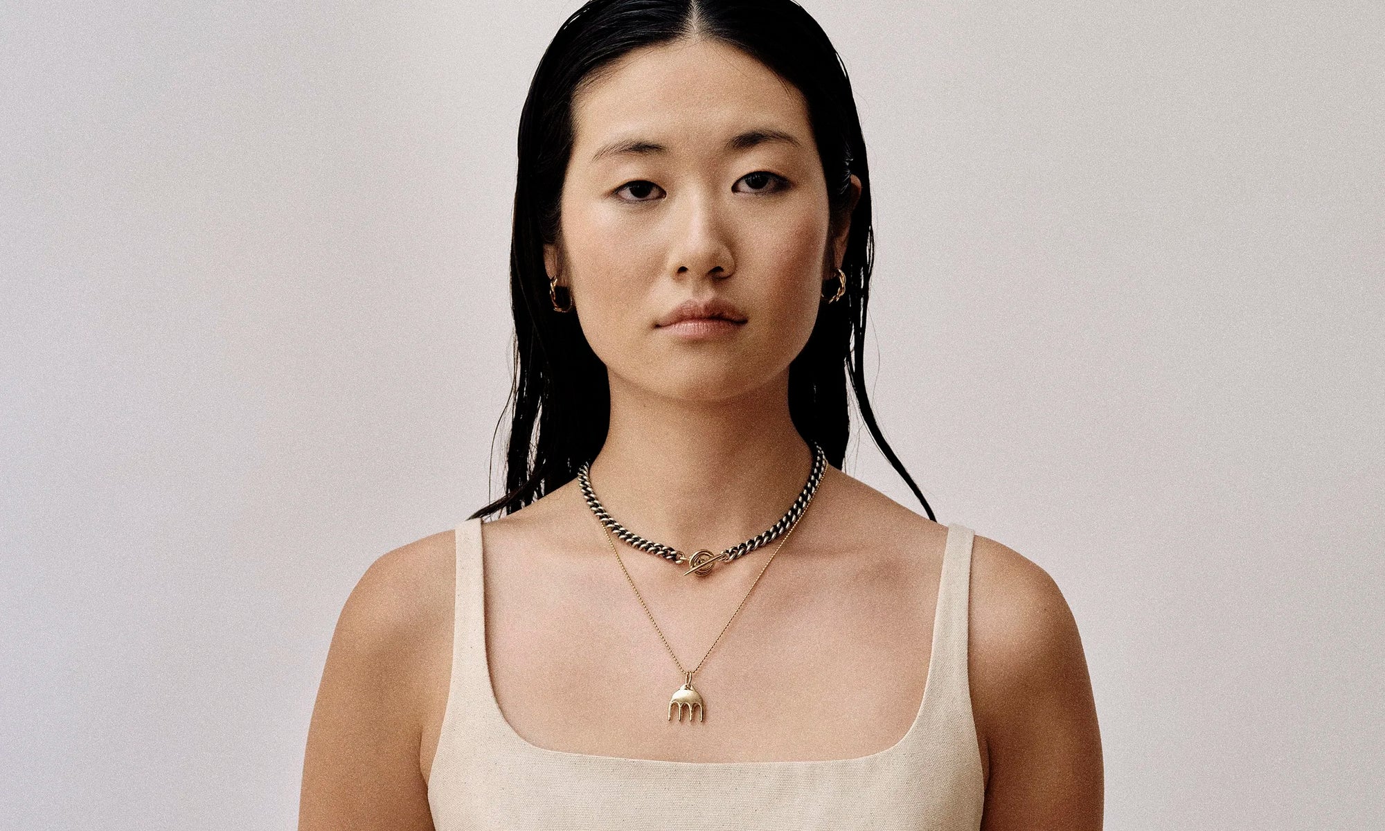 Model Rachel wears the Helix Hoops, two-tone Vortex Necklace, and Ariel's Comb Necklace. All sustainably handmade in recycled 14k gold by Talisman Fine Jewelry.