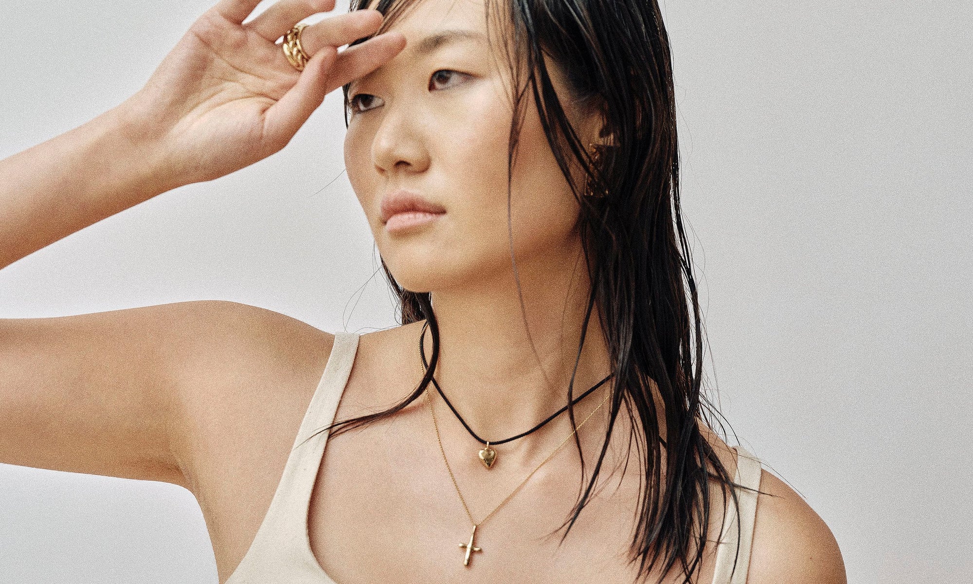 Model Rachel wears the Plane Earrings, Zoe's Heart Necklace on silk cord and Christ Consciousness Necklace, along with the Portal Ring, Helix Band and Rollo Band. All sustainably handmade in recycled 14k gold by Talisman Fine Jewelry.