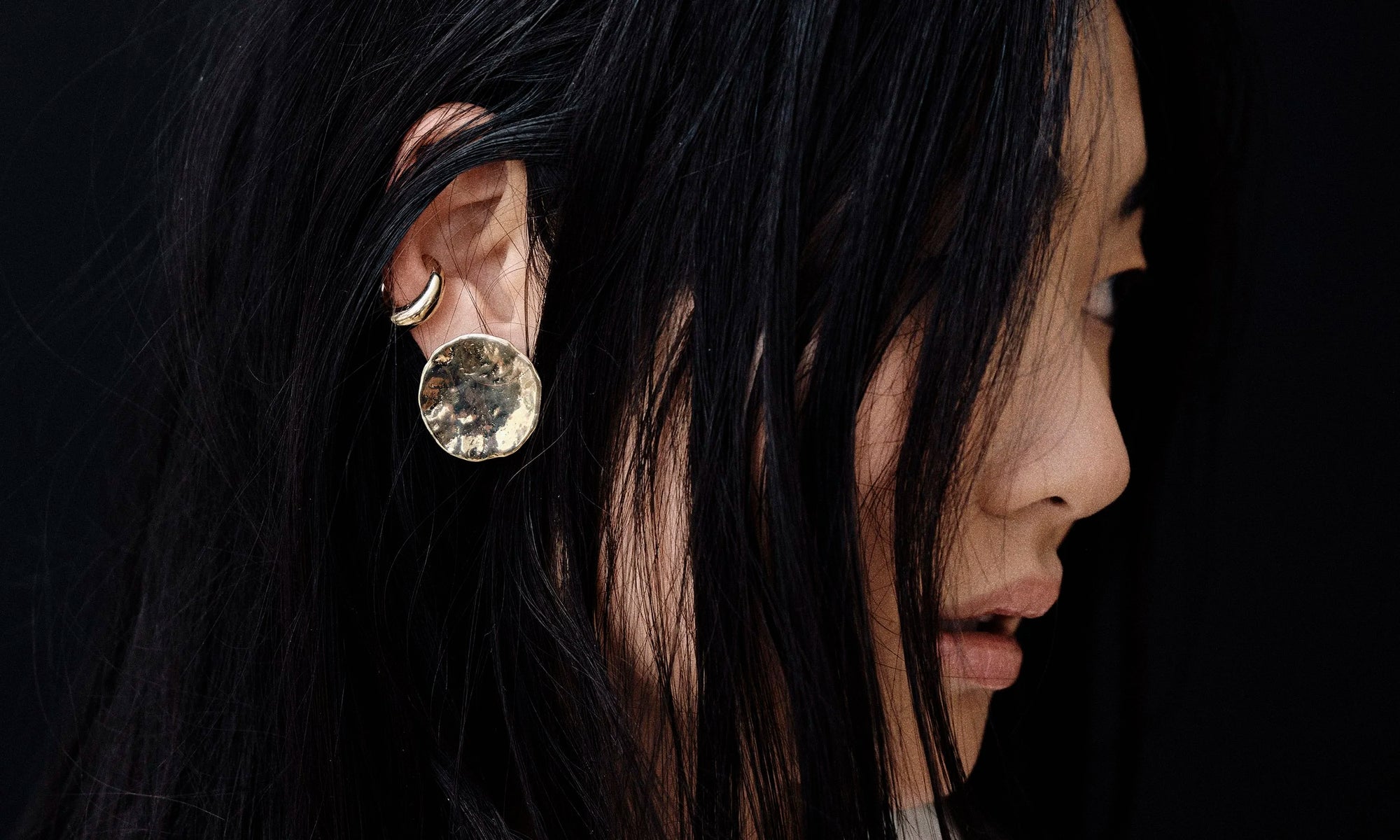 Model Rachel wears the Soleil Earring and Delphi Ear Cuff. Each piece of 14k gold jewelry is hand sculpted by Talisman Fine Jewelry.