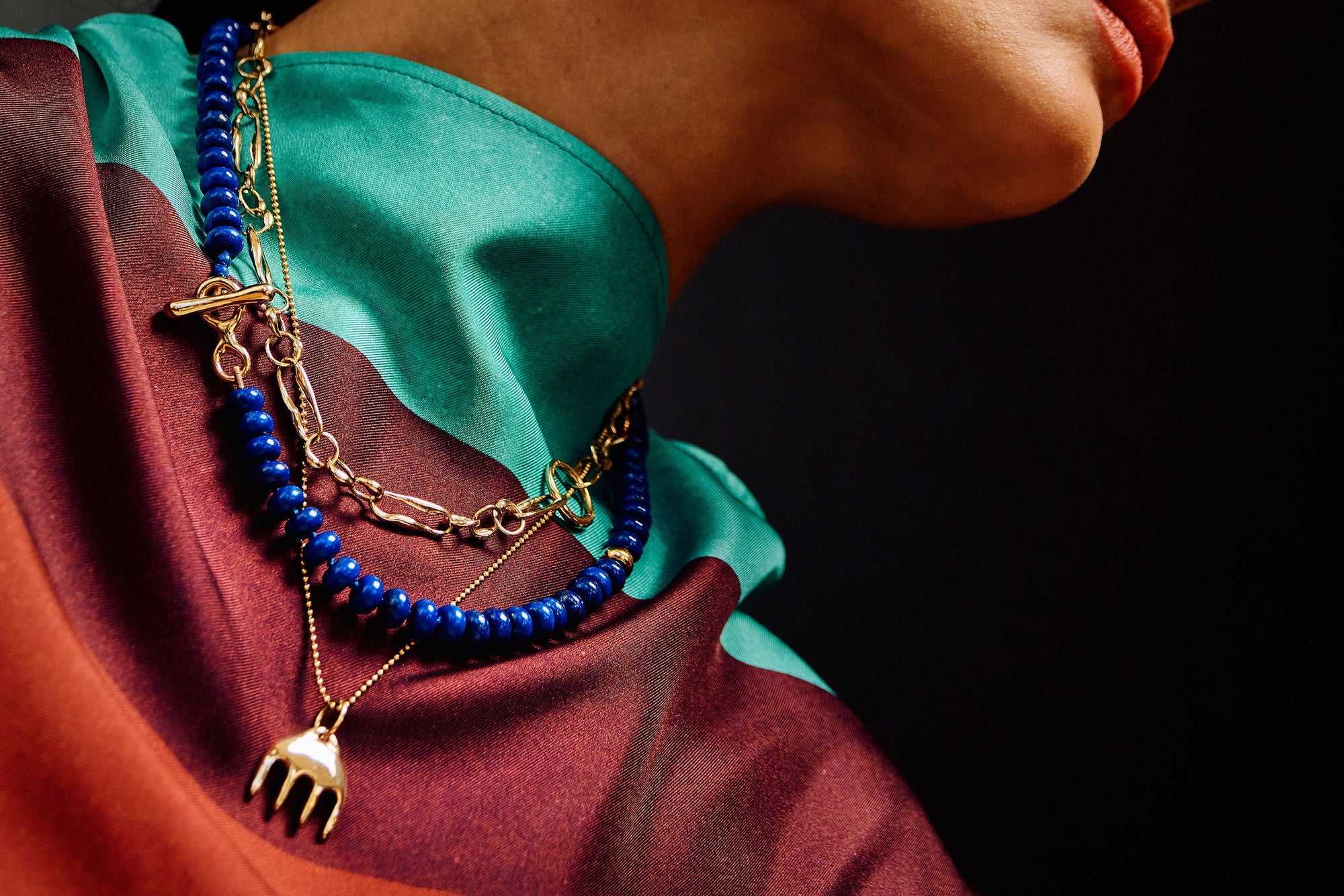 Thaiara wears the Metanoia Chain, Prayer Necklace in Lapis, and Ariel's Comb Necklace, layered together to highlight contrasting textures and color.