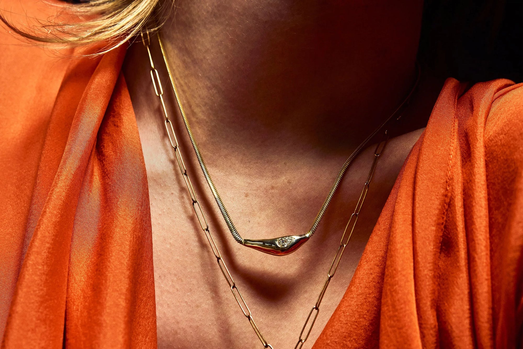 Model Rae wears the Where The Light Comes Through Necklace and the Protective Eye Y Necklace, each with handcrafted details using recycled solid 14k gold.