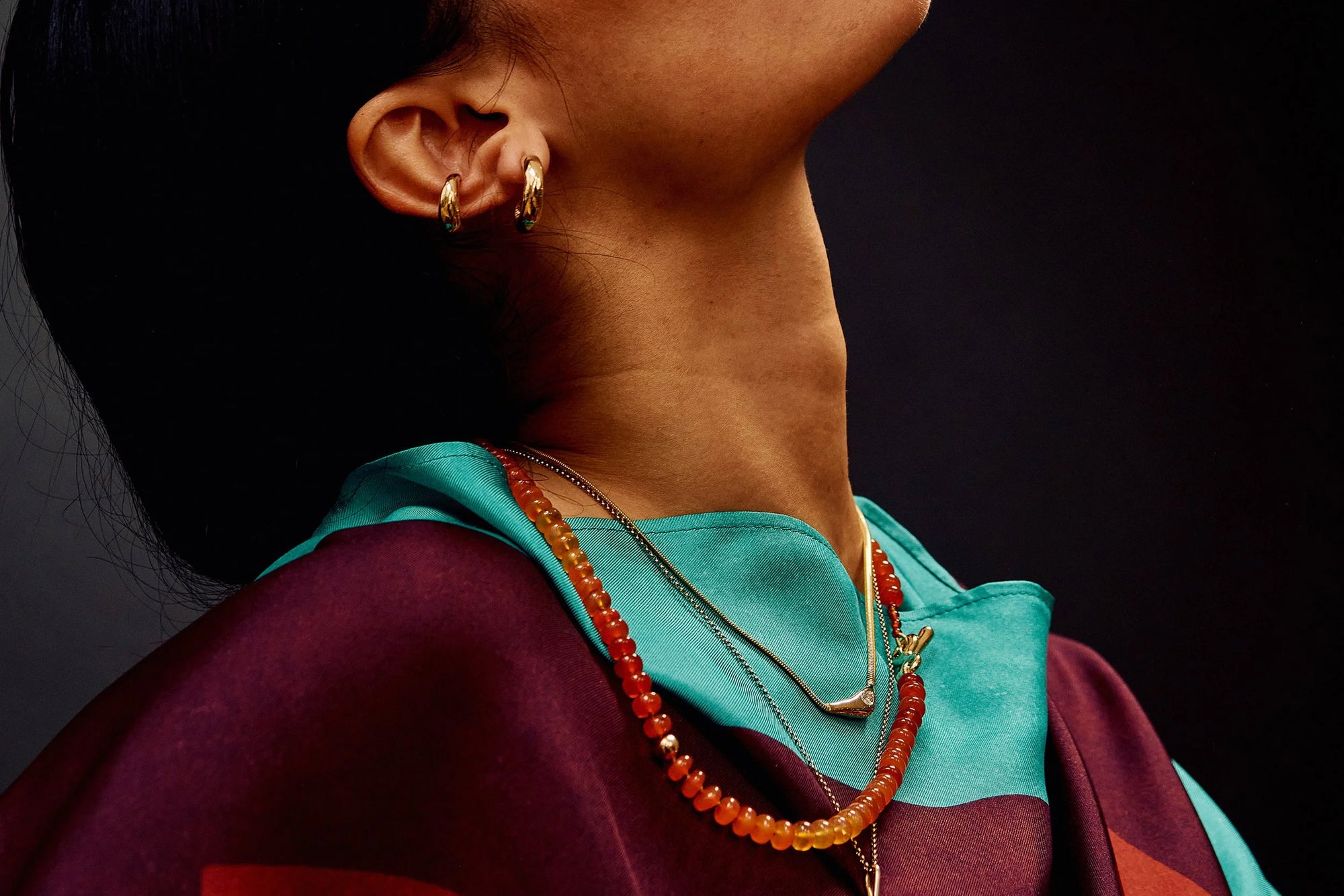 Model Thaiara wears Delphi Ear Cuff, Rollo Hoops, Where The Light Comes Through Necklace, and Prayer Necklace in Carnelian.