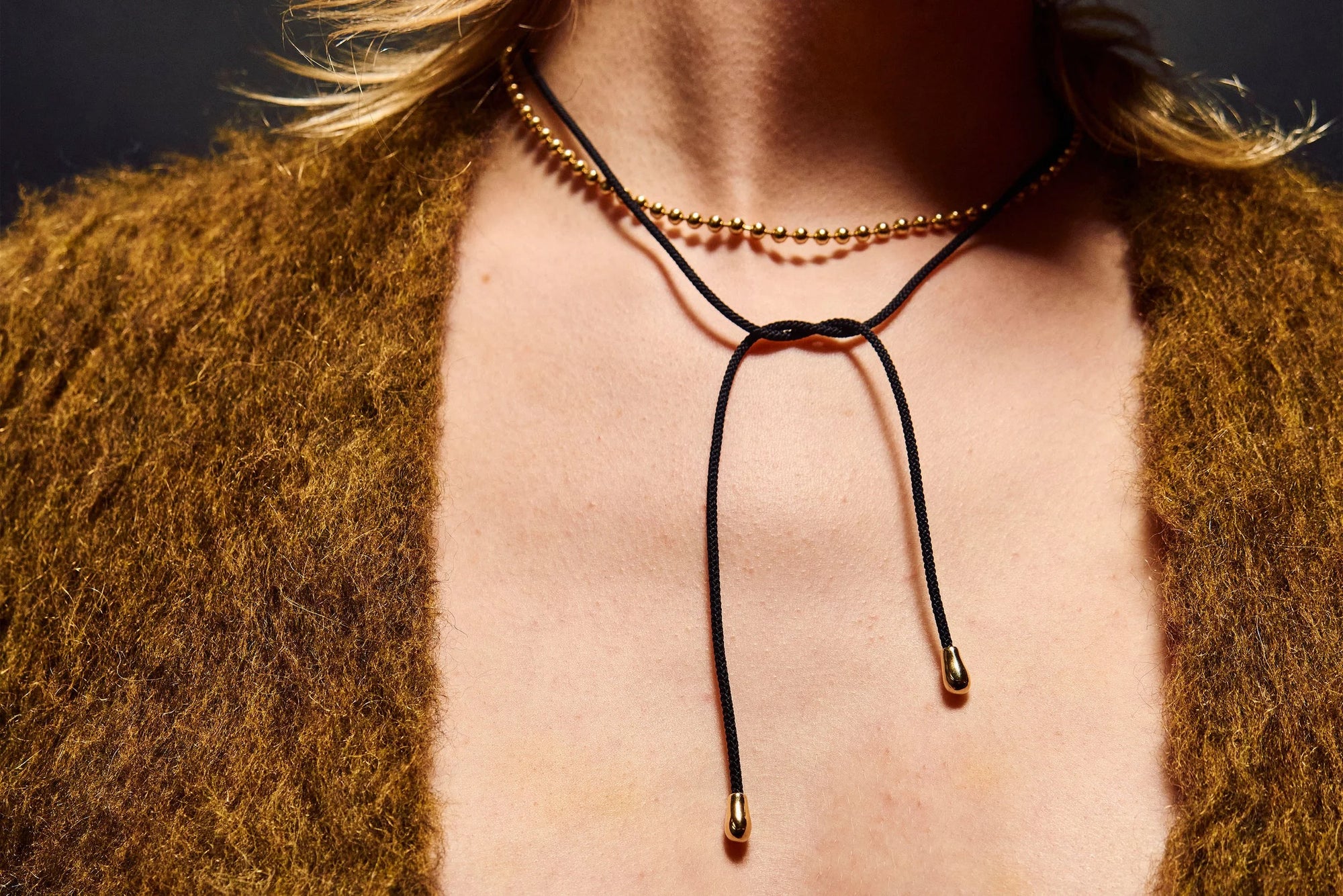 Model Rae wears the solid, ethically-sourced 14k gold Galaxy Chain and Drip Silk Cord Choker, a Japanese silk cord accented by two handmade 14k gold nubs that can be styled at the front or back.