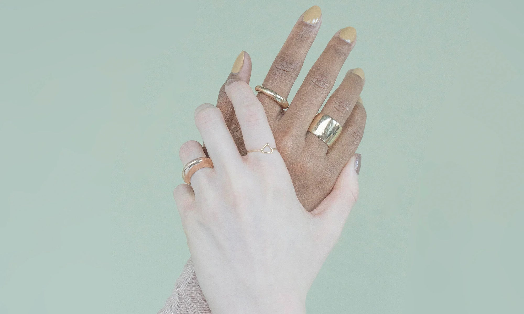 Let us hold each other up. Models Nyasia Wyani and Alicia Myers wear rings from the Talisman Fine Jewelry Alchemy Collection. From left: The Persephone Ring, Triangle Shape Ring, Rollo Band, and Demeter Cigar Band. All sustainably handmade in recycled 14k gold using traditional lost-wax casting techniques.
