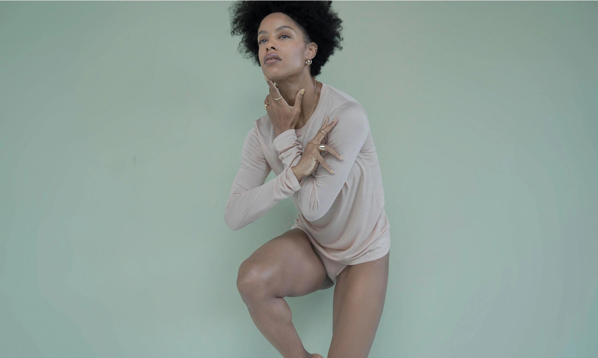 Model Alicia Myers poses in the Talisman Fine Jewelry Alchemy Collection. Clockwise from top left: The Ra Pinky Signet, Rollo Band, Rollo Hoops, Aphrodite Hugs, Mini Rainbow Stud, Petite Rollo Band, Demeter Cigar Band. All sustainably handmade in recycled 14k gold, using traditional lost-wax casting techniques.