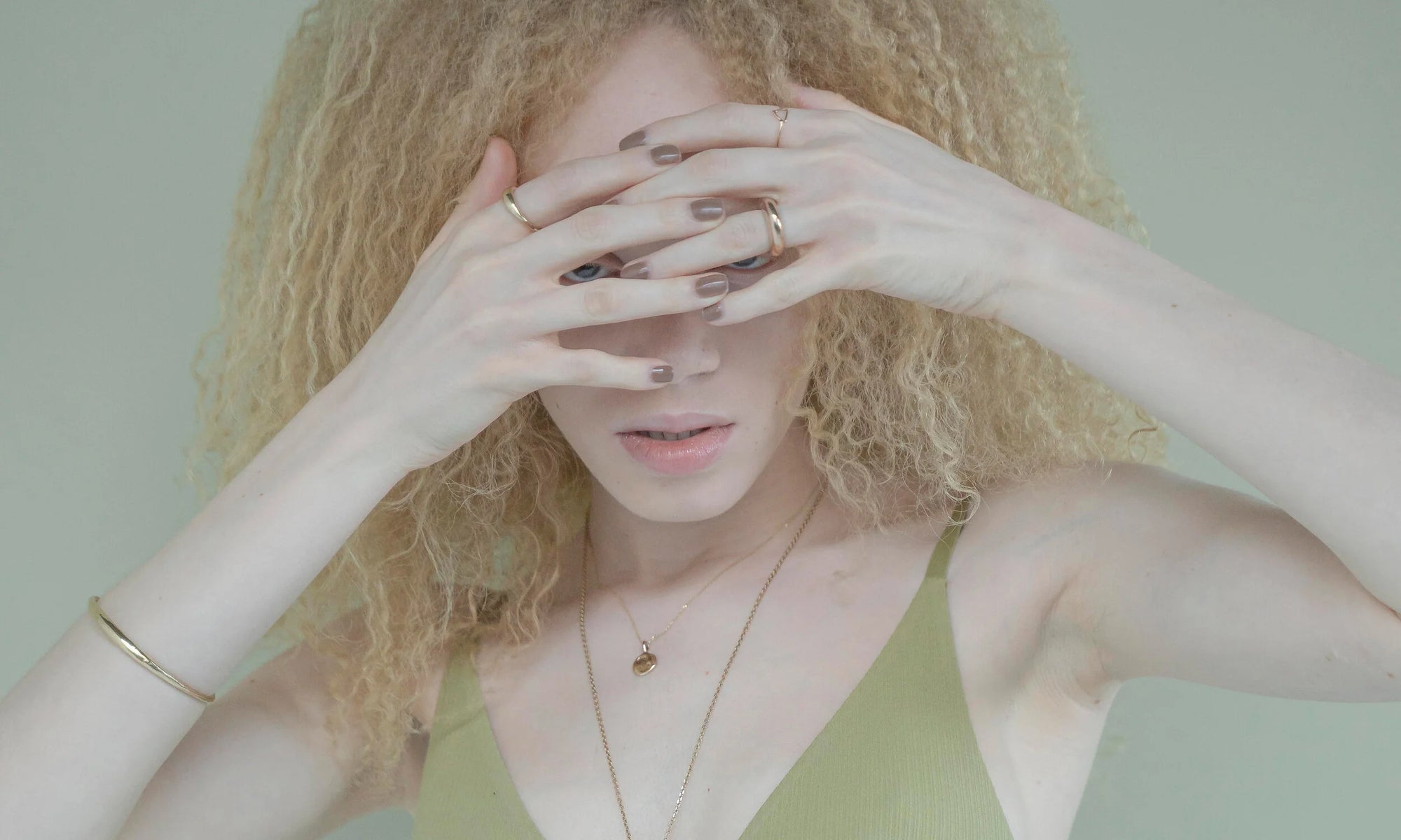 Model Nyasia Wyani wears the Portal Bracelet, Michael Amulet Necklace, Persephone Ring, Portal Ring, and Triangle Shape Ring. All sustainably handmade in recycled 14k gold using traditional lost-wax casting techniques.