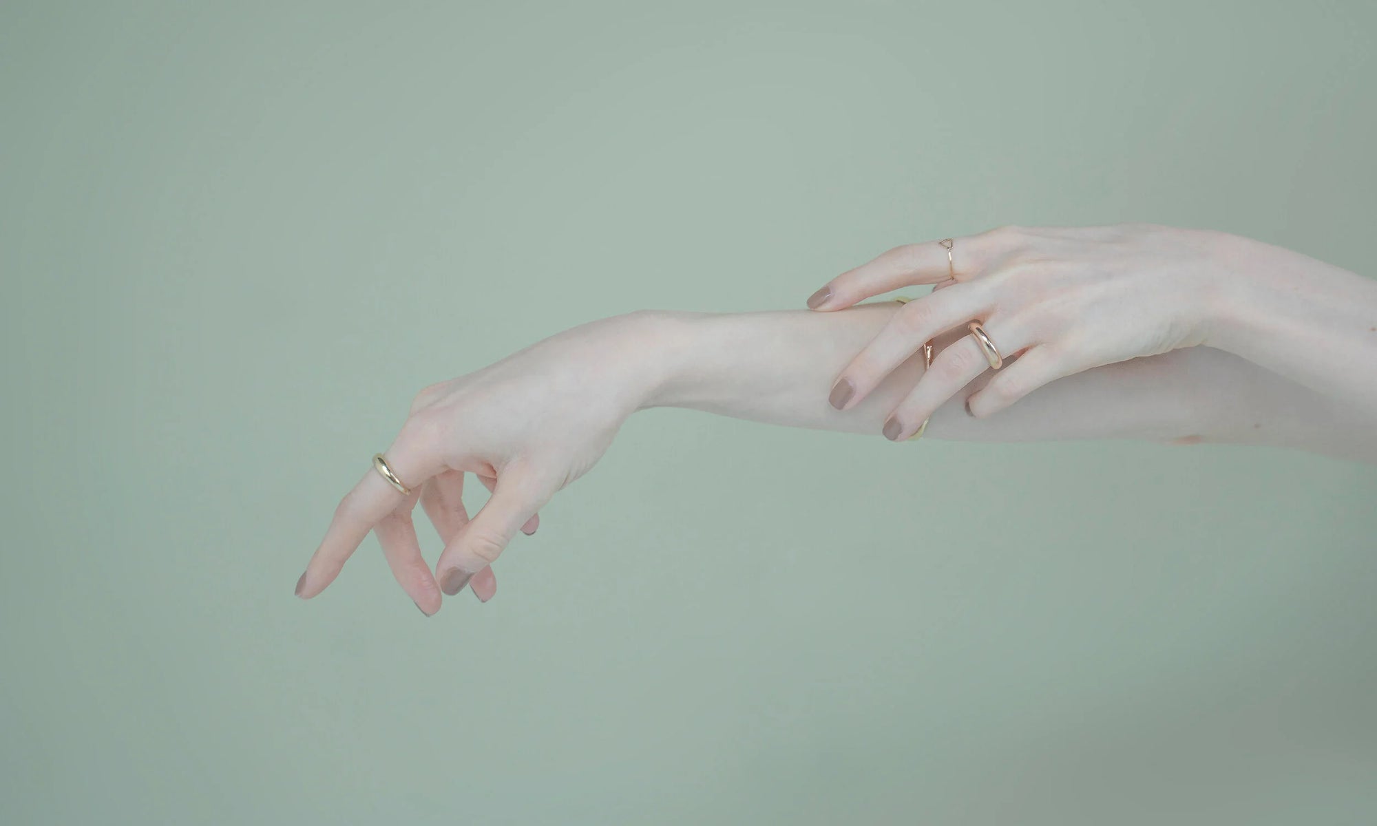 Model Nyasia Wyani wears the Portal Ring, the Triangle Shape Ring, the Persephone Ring, and the Portal Bracelet. All sustainably handmade in recycled 14k gold, using traditional lost-wax casting techniques.