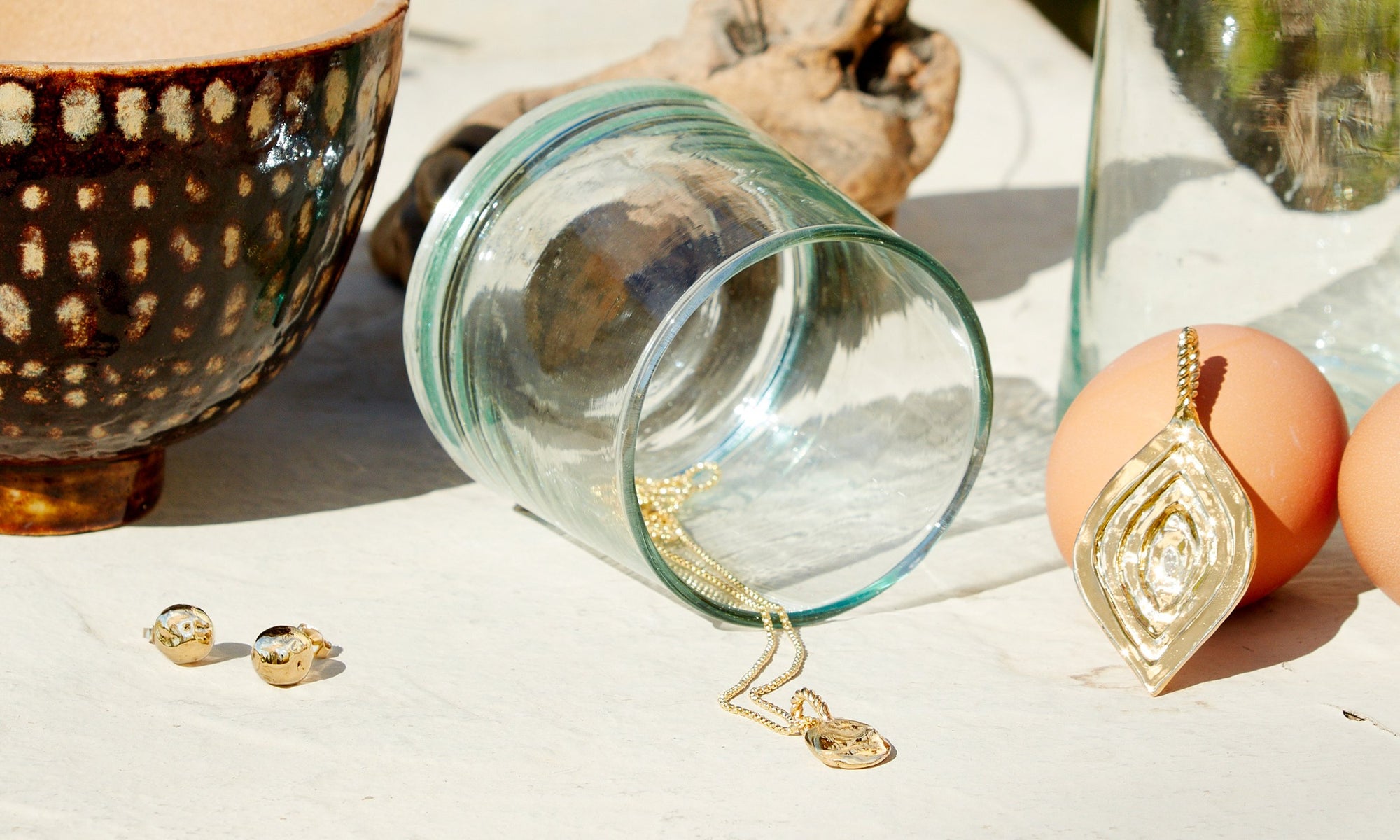 From left: The Central Sun Earrings, Phoenix Amulet Necklace, and Mary Pendant. All sustainably handmade in recycled 14k gold, with a reclaimed antique marquise diamond in the Mary Pendant.