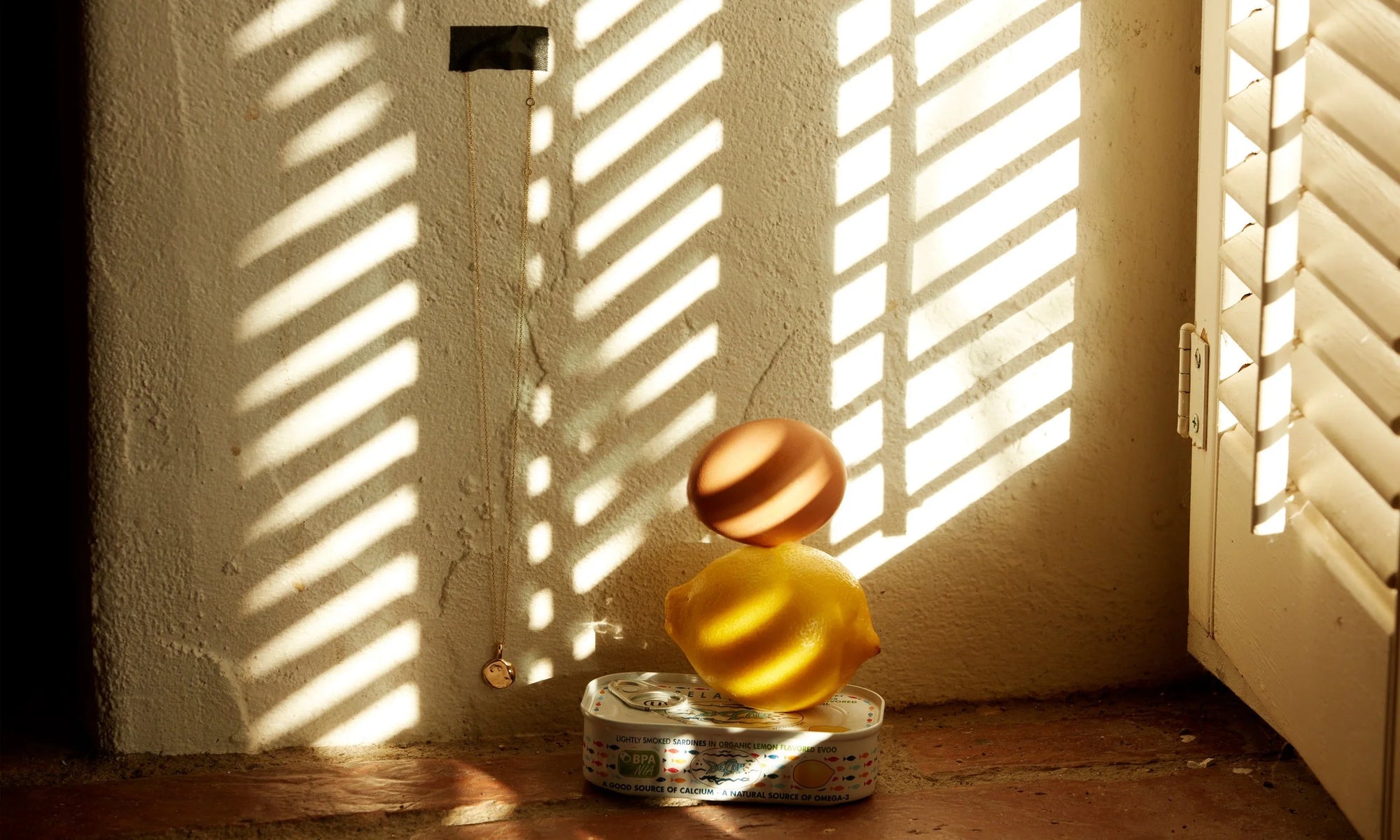 The Michael Amulet Necklace takes in the afternoon sun as it peeks through the blinds