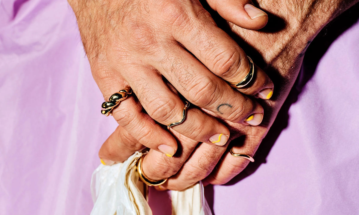 River wears, from left, the Helix Ring, Wave Theory Ring, Portal Ring, and the Shapeshifter Ring. Lilac dress and bag by Kate Towers.
