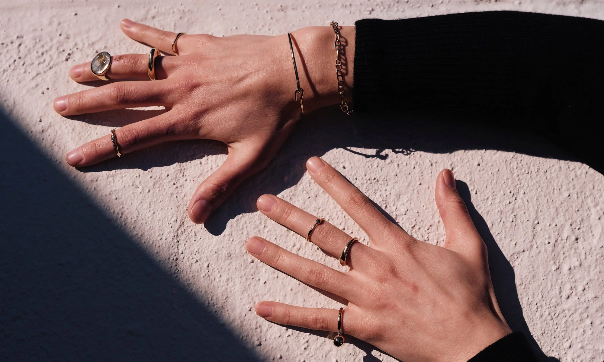Model Erika Rodriguez wears the Anchored Bracelet and Orbit Bracelet, and rings from top: Sirius B Ring, Persephone Ring, Ra Signet and Petite Helix Band, Ouroboros Ring, Portal Ring and Central Sun Ring. All sculpted and handmade in solid, recycled 14k gold.