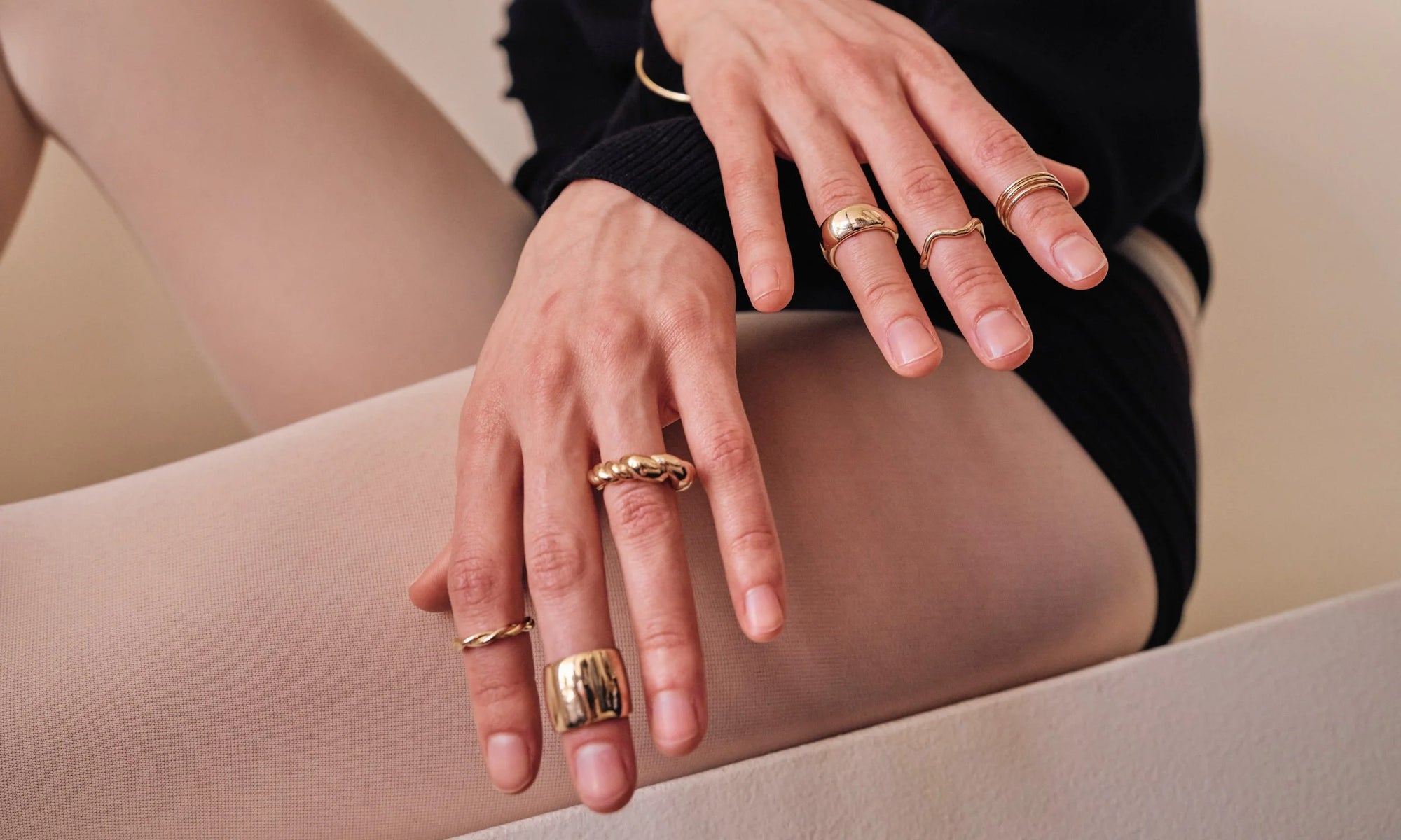 Model Erika Rodriguez wears the Petite Helix Band, Demeter Cigar Band, Helix Dome Ring, Conjunct Cigar Band, Shapeshifter Ring and Infinite Ring Stack. All handmade in recycled 14k gold.