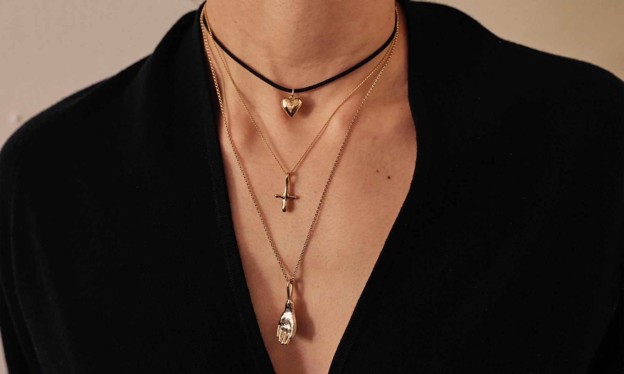 From top: the Zoe's Heart Necklace on silk cord, Petite Christ Consciousness Necklace, and Held Necklace. All sculpted and handmade in recycled 14k gold.