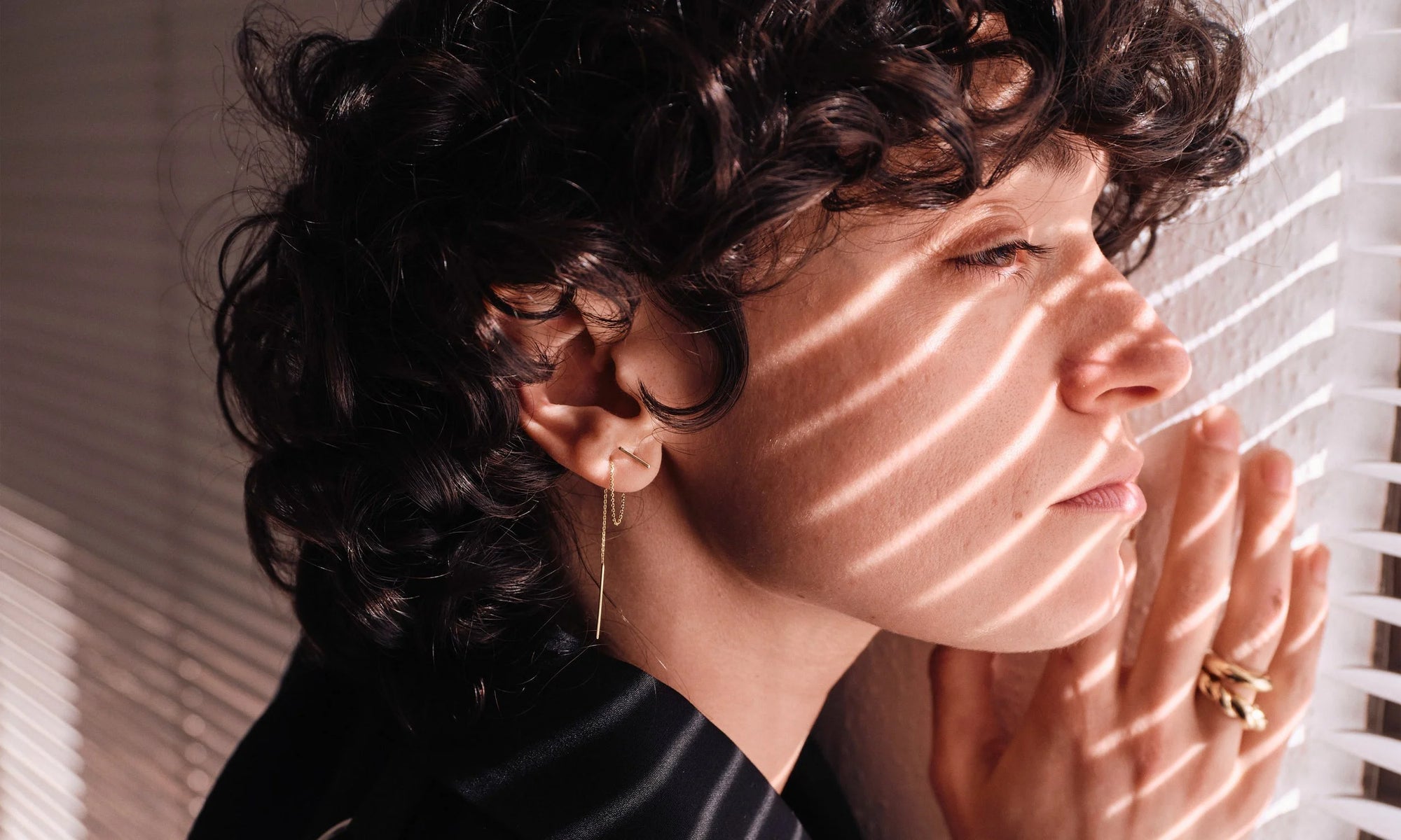 Erika wears the Linear Threader earring, handmade in recycled 14k gold.