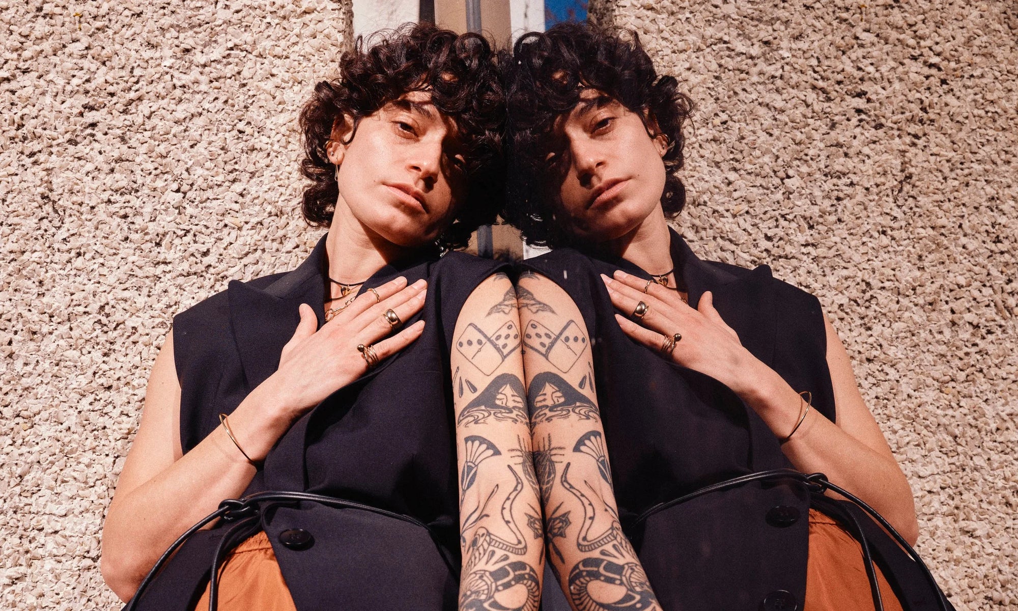 Erika wears the Orbit Bracelet, Central Sun Ring with the Infinite Ring Stack, Conjunct Cigar Band, Petite Helix Band, Metanoia Handmade Chain, Flow Chain, Zoe's Heart Necklace on silk cord, and Sanguine Drop Earrings paired with the Diamond Mini Orb Stud. All handmade in recycled 14k gold.