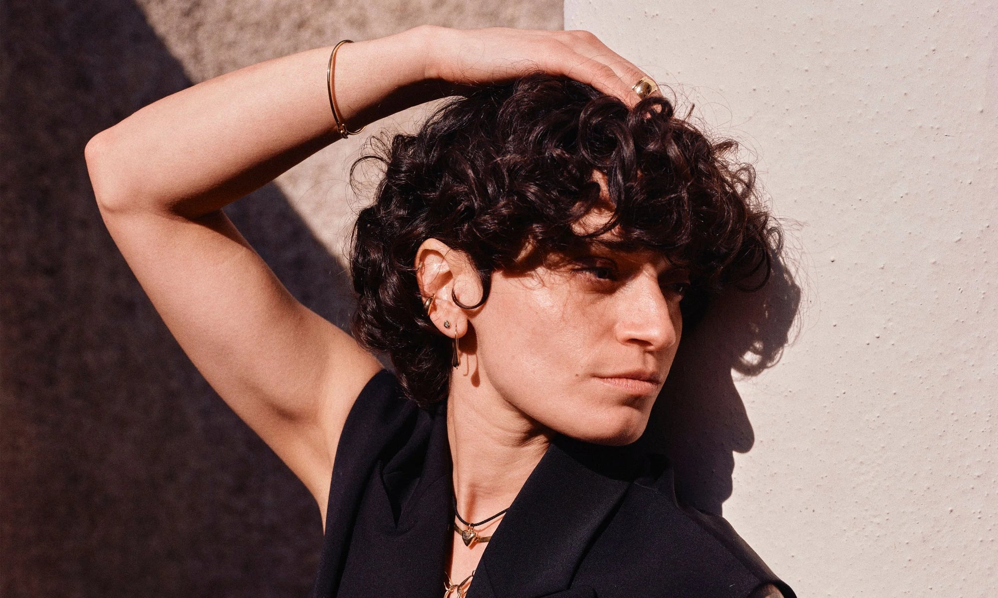 Erika wears the Orbit Bracelet, Conjunct Cigar Band, Delphi Ear Cuff, Diamond Mini Orb Stud, and Sanguine Drop Earrings, along with the Zoe's Heart Necklace on silk cord, Flow Chain and Metanoia Handmade Chain. All hand-sculpted and cast in recycled 14k gold.