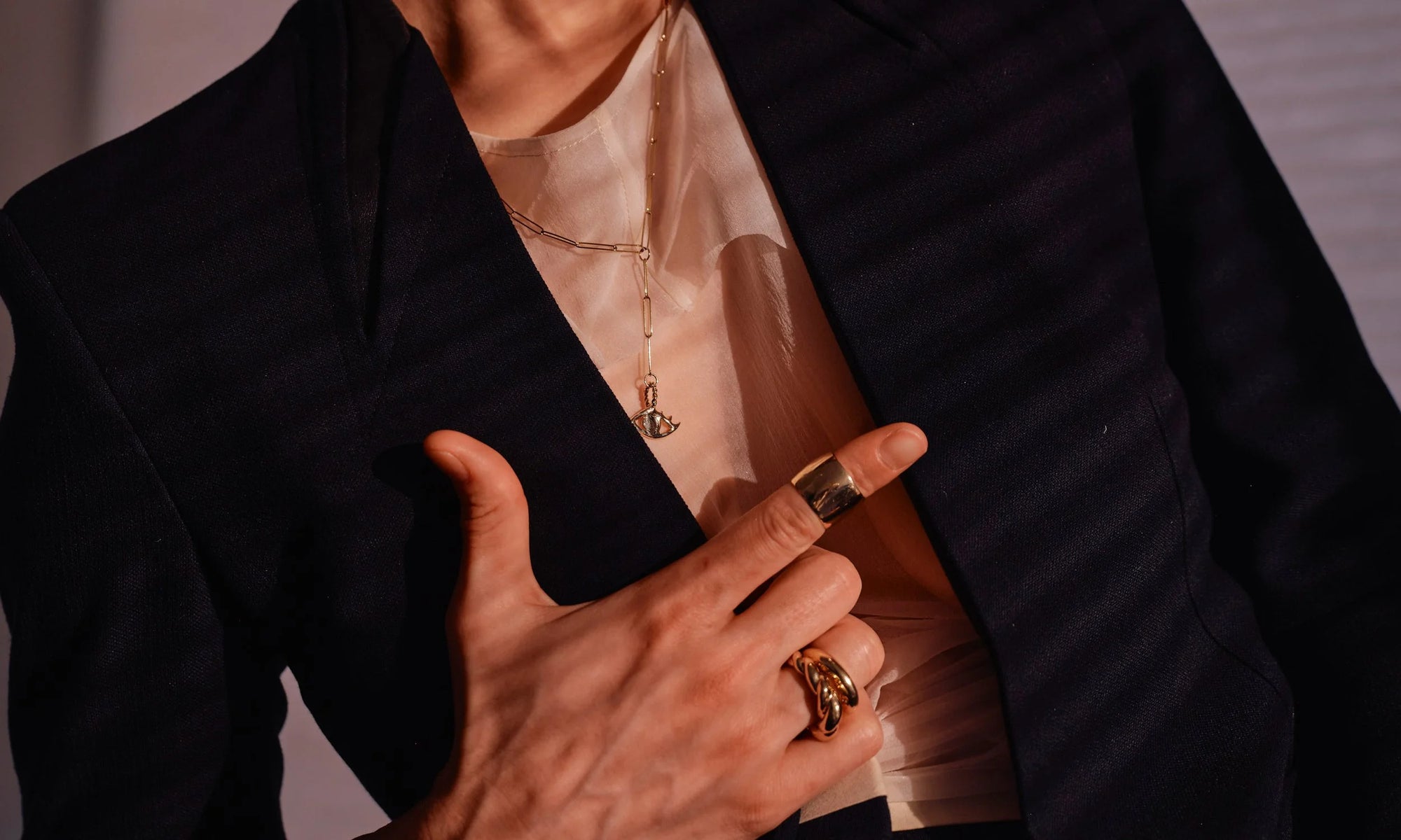 Erika wears the Protective Eye Y Necklace, the Demeter Cigar Band, the Persephone Ring and the Helix Dome Ring. All handmade in recycled 14k gold.