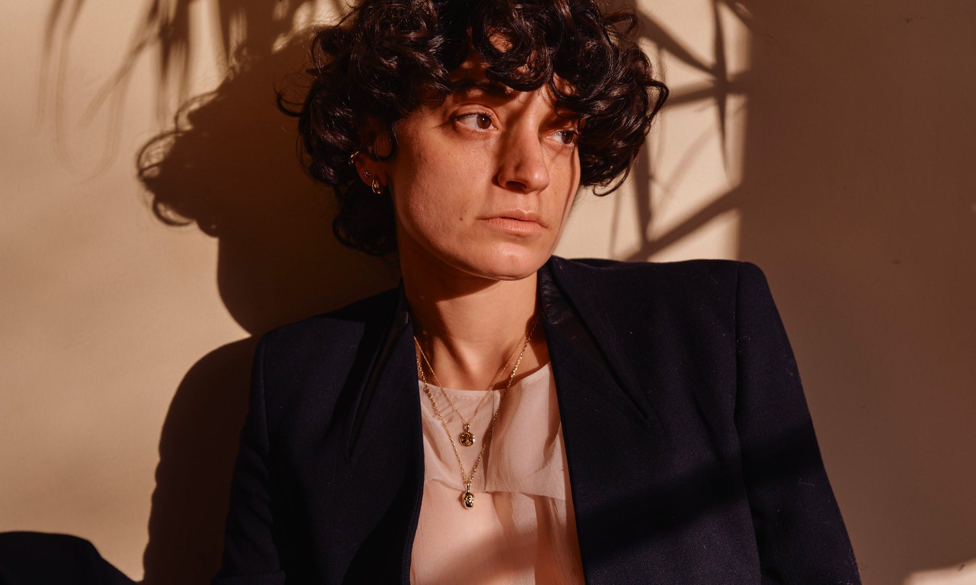 Erika wears, from top left: Delphi Ear Cuff, Diamond Mini Orb Stud, Sanguine Stud Earrings, Michael Amulet Necklace, and the Soft Body Venus Necklace. All handmade in recycled 14k gold.