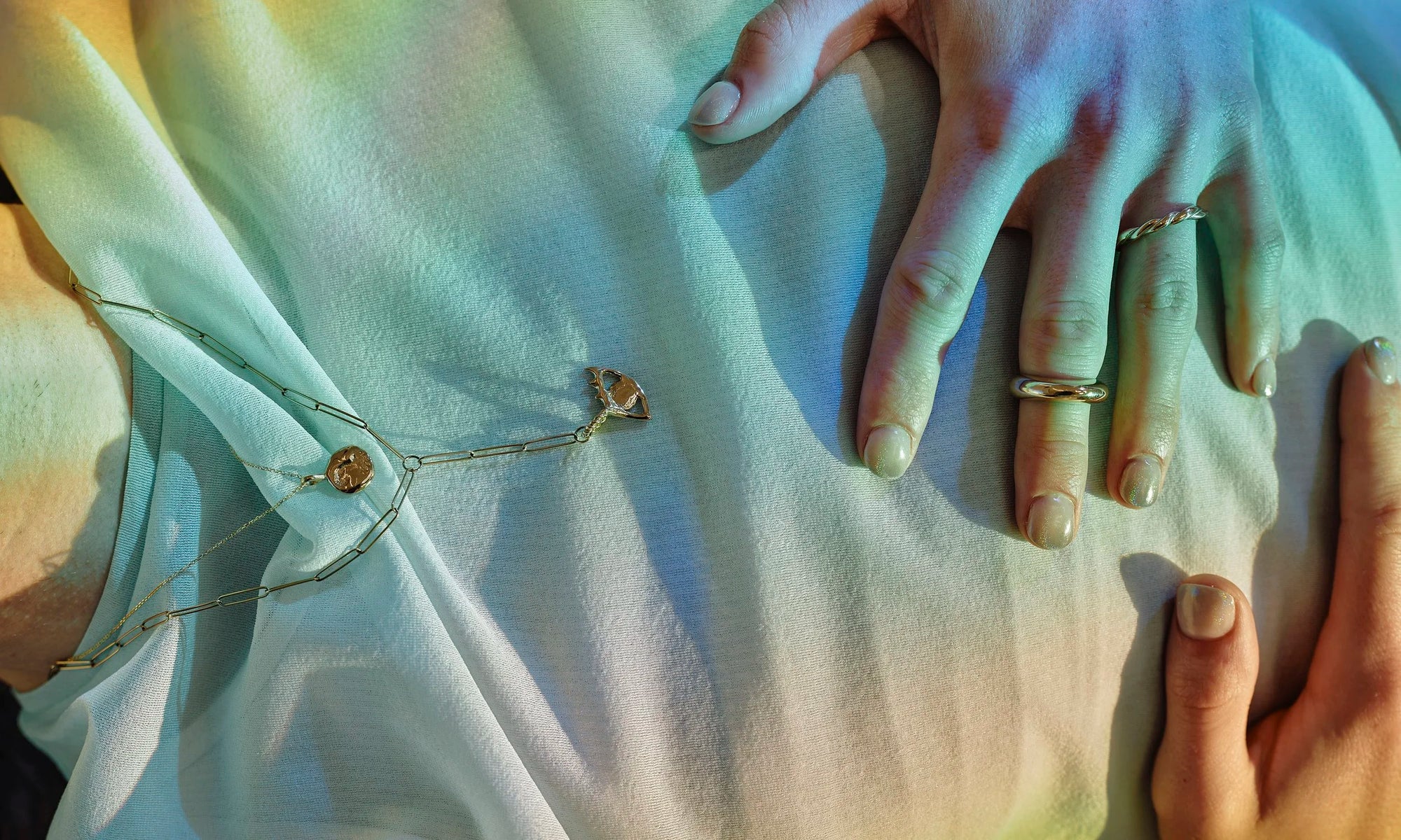 Handmade fine gold jewelry, hand-sculpted and ethically sourced by Talisman Fine Jewelry. Apple wears the Persephone Ring, Petite Helix Band, Protective Eye Y Necklace, and Alex Engraveable Amulet Necklace.