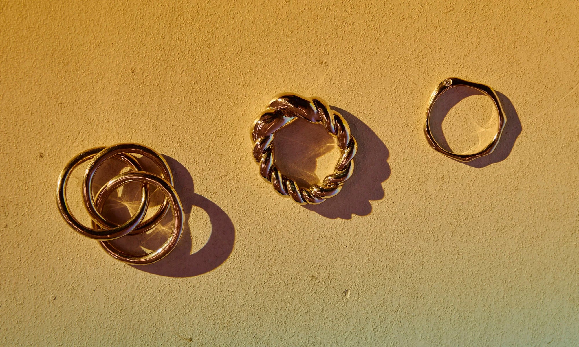 Hand-sculpted, recycled 14k gold rings with reclaimed diamonds handmade by Talisman Fine Jewelry. Talisman's SS25 collection featuring the Interconnection Trio Ring, Diamond Sirius B Ring, and Helix Dome Ring.