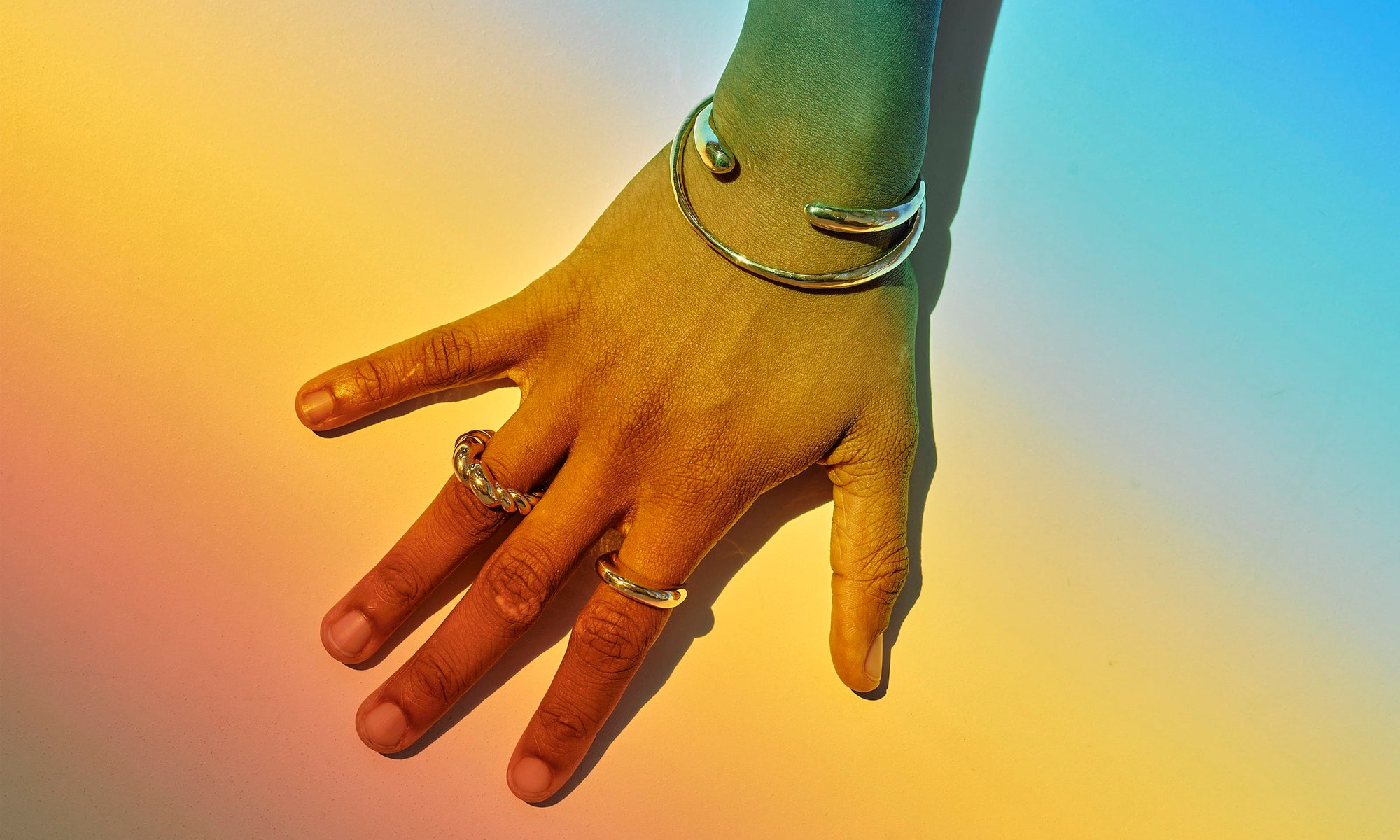 Ethically sourced, recycled 14k gold minimal rings and bracelets, hand-sculpted by Talisman Fine Jewelry. Royal wears the Helix Dome Ring, Persephone Ring, Inverse Cuff Bracelet, and Portal Bracelet.