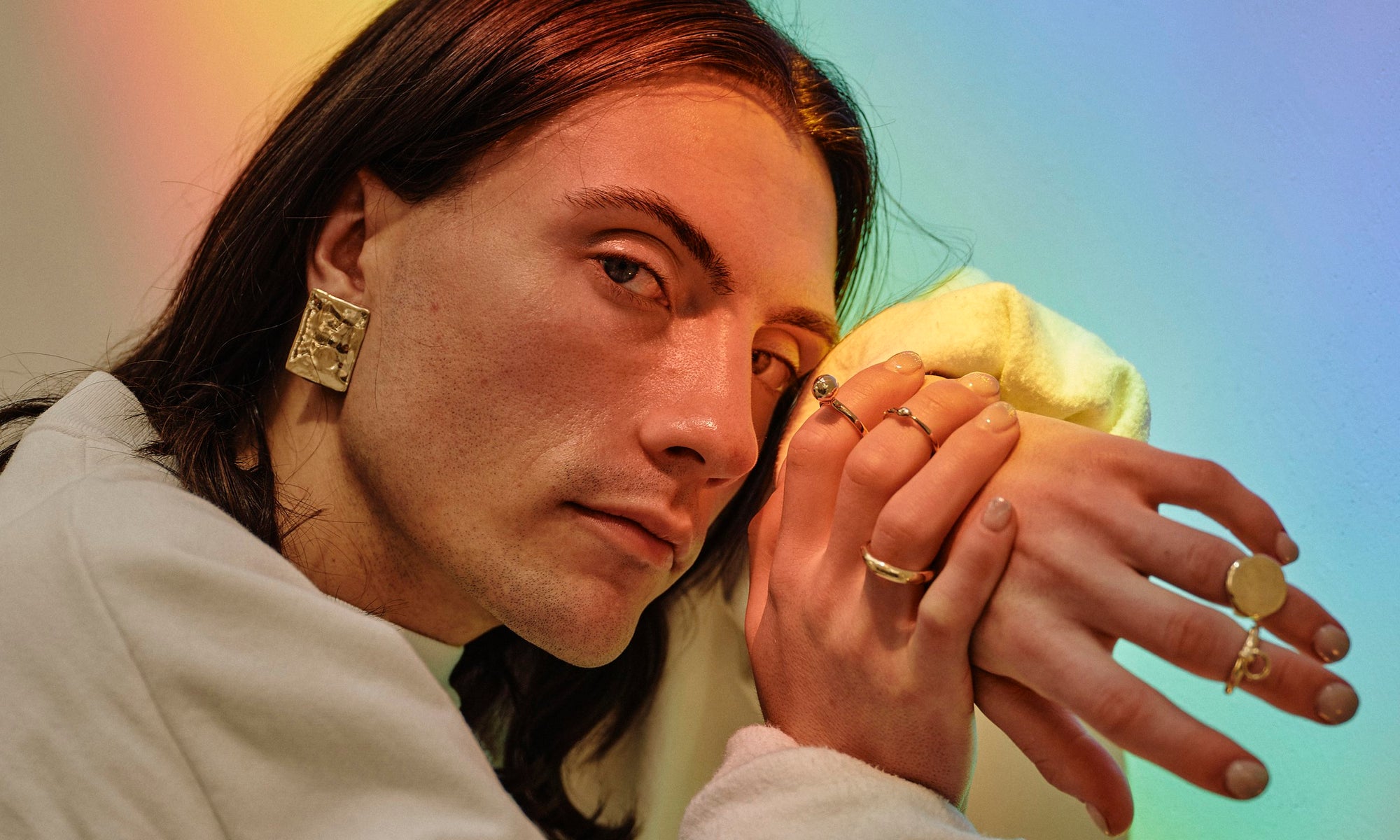 Recycled 14k solid gold rings and minimal statement earrings, hand-sculpted by Talisman Fine Jewelry. Apple wears the Plane Earrings, Petite Rollo Band, Ouroboros Ring, Central Sun Ring, Interdependence Ring, and Ra Pinky Signet Ring.