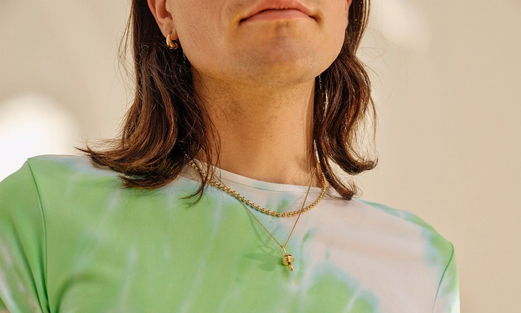 Hand-sculpted fine gold jewelry, hand-sculpted and ethically sourced by Talisman Fine Jewelry. Apple wears the Gold Galaxy Chain, Shroom Necklace, Athena Hug Hoops.