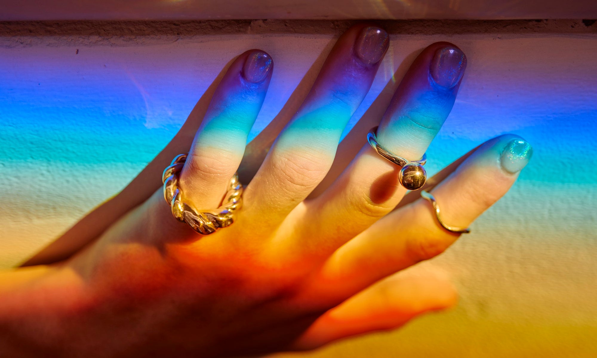 Ethically sourced, recycled 14k gold minimal rings, hand-sculpted by Talisman Fine Jewelry. Apple wears the Helix Dome Ring, Central Sun Ring, and Wave Theory Ring.