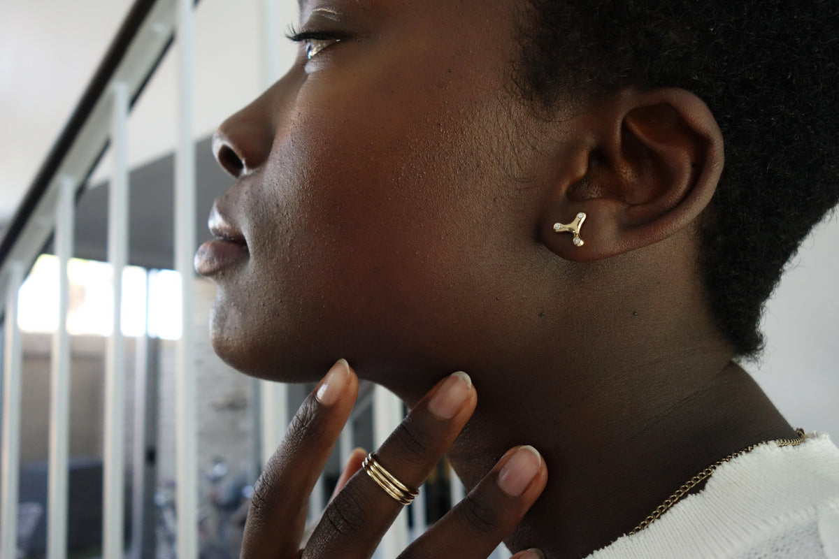 talisman fine jewelry constellation earrings are an abstract, amorphous shape flush set with three mismatched round diamonds.  paired here with the infinite ring stack.