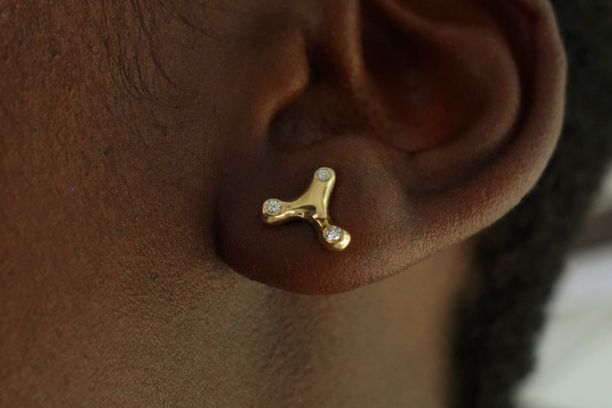 the constellation earrings, hand-sculpted in recycled 14k gold with three mismatched inset diamonds